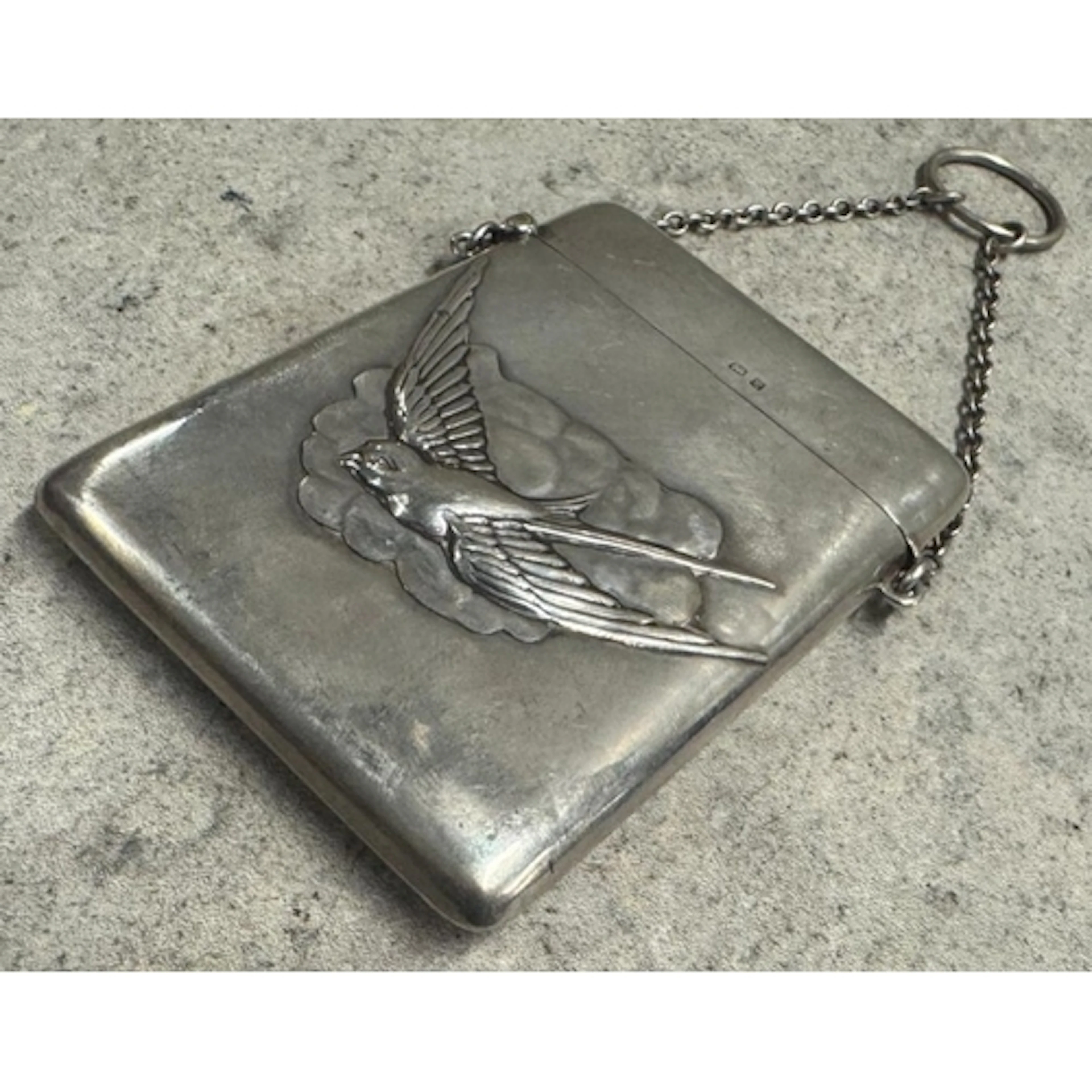 A novelty silver card case chased with bird decoration to ce...