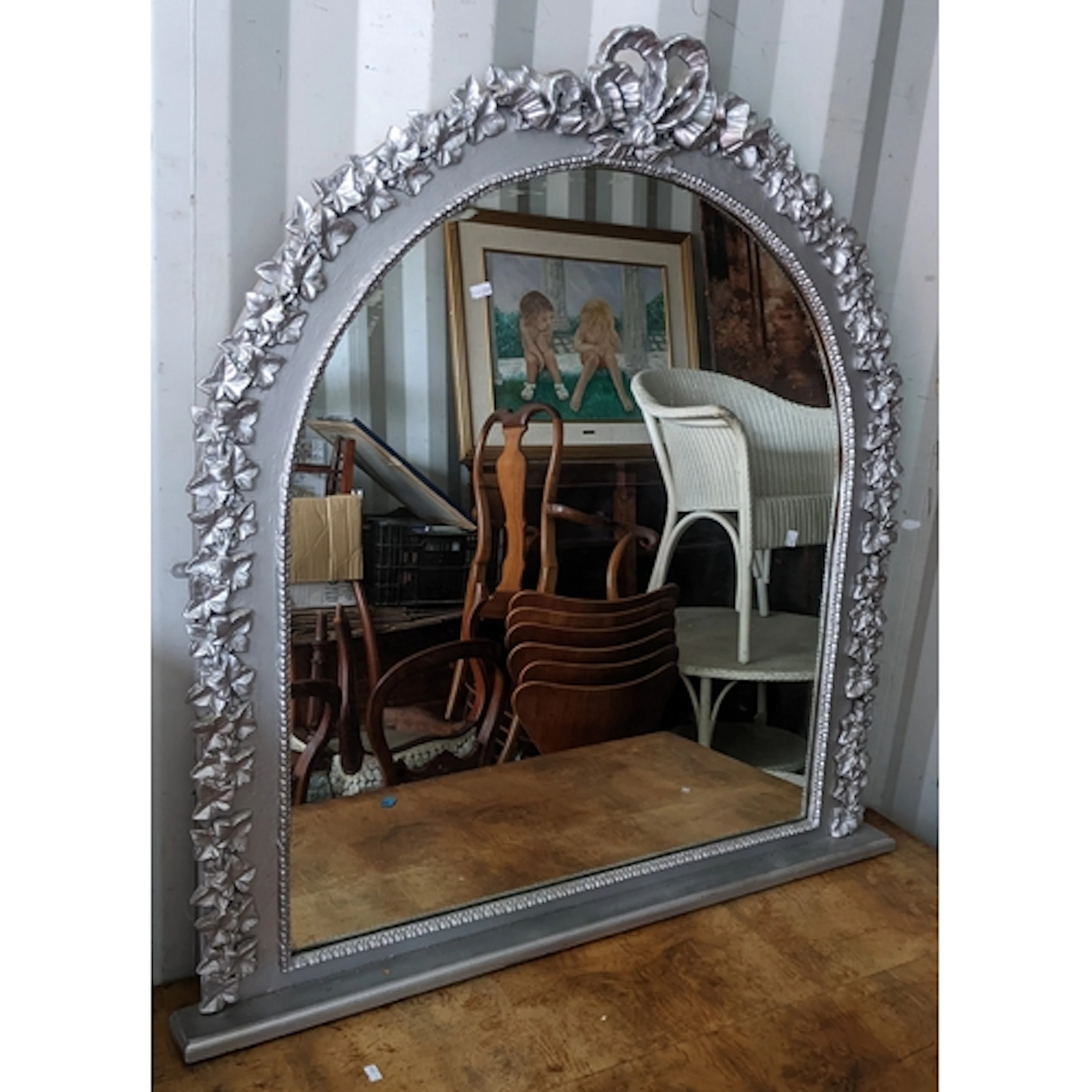 A modern silver coloured overmantel mirror having a moulded ...