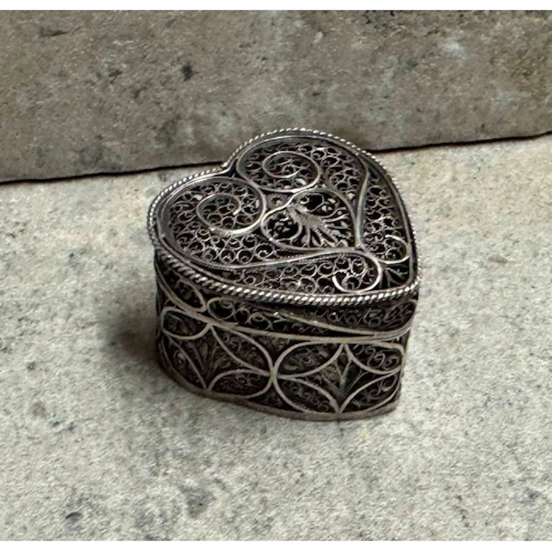 A heart-shaped silver filigree box. Approx. 13 grams. Est. £...