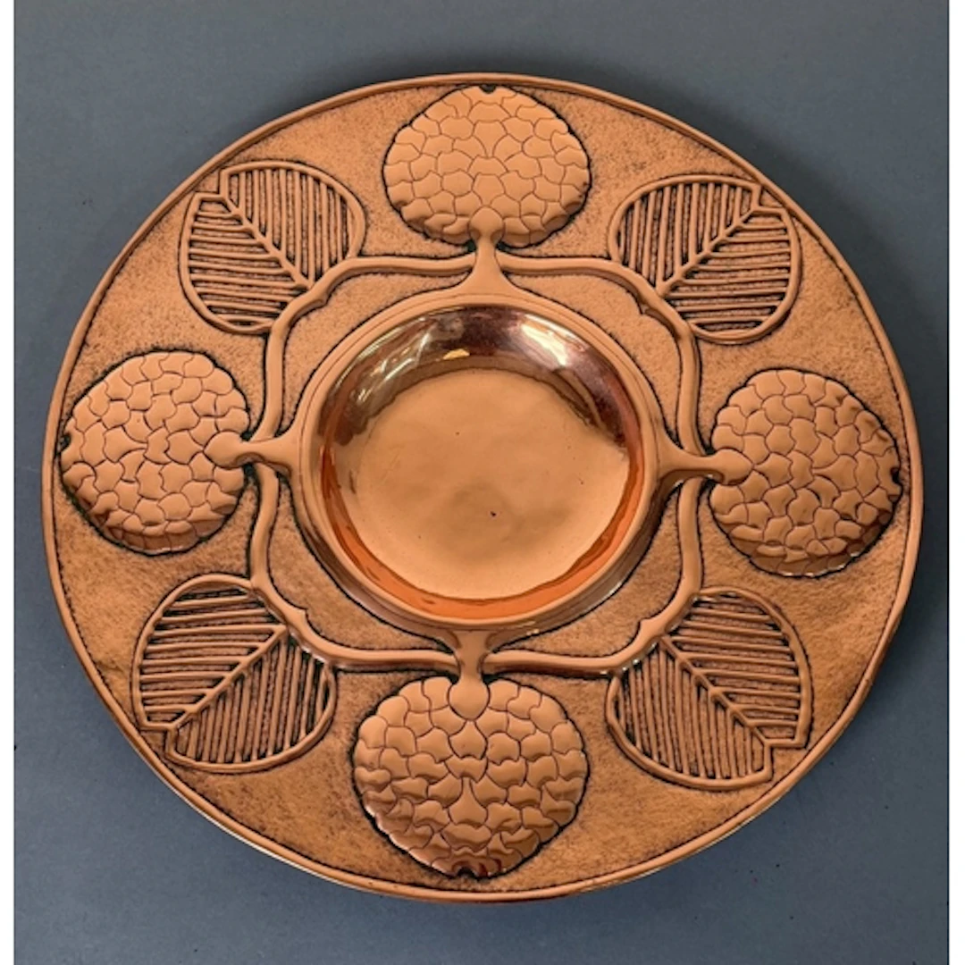 An Arts and Craft style Copper charger with central recessed...