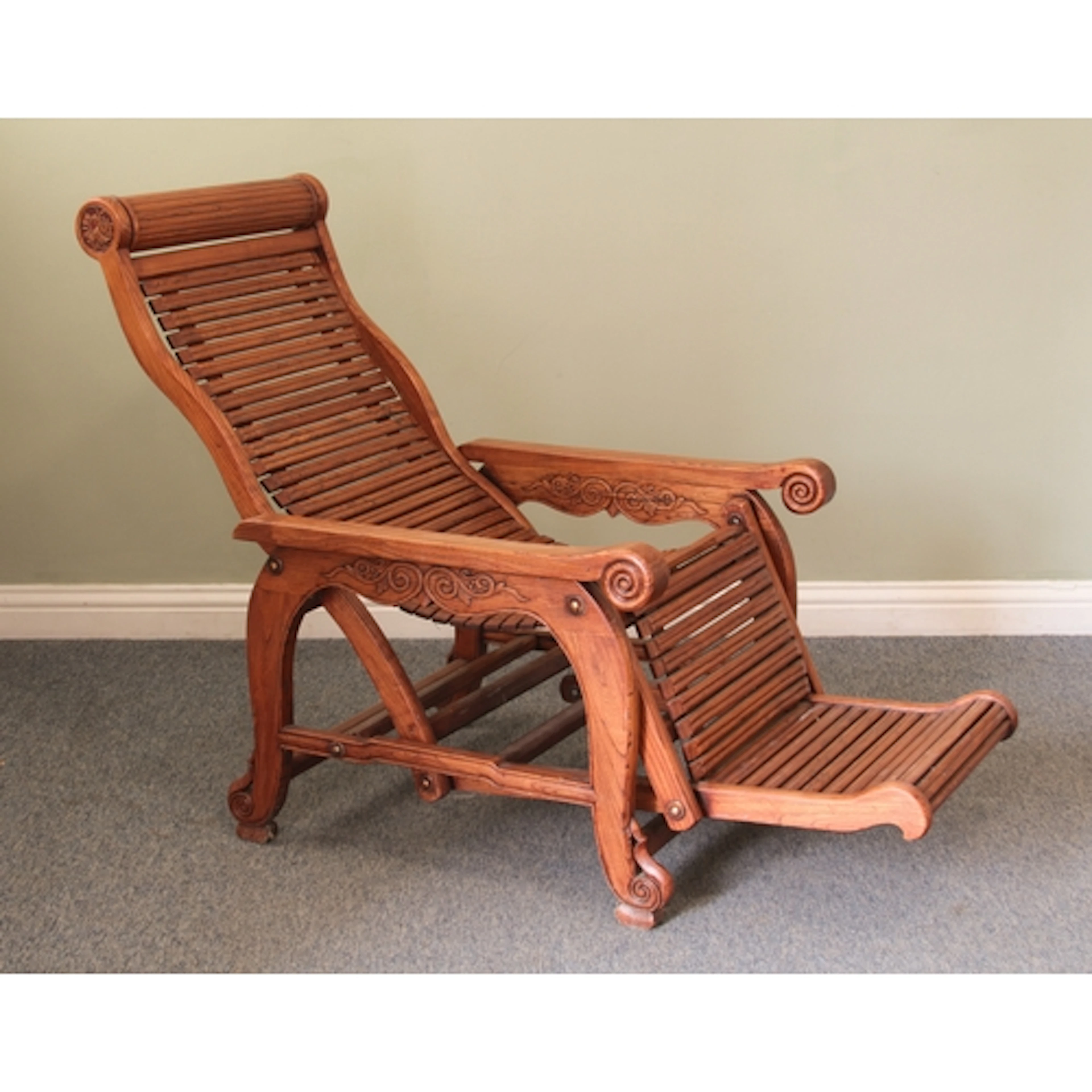 A Chinese hardwood 'moongazing' recliner - with long carved ...