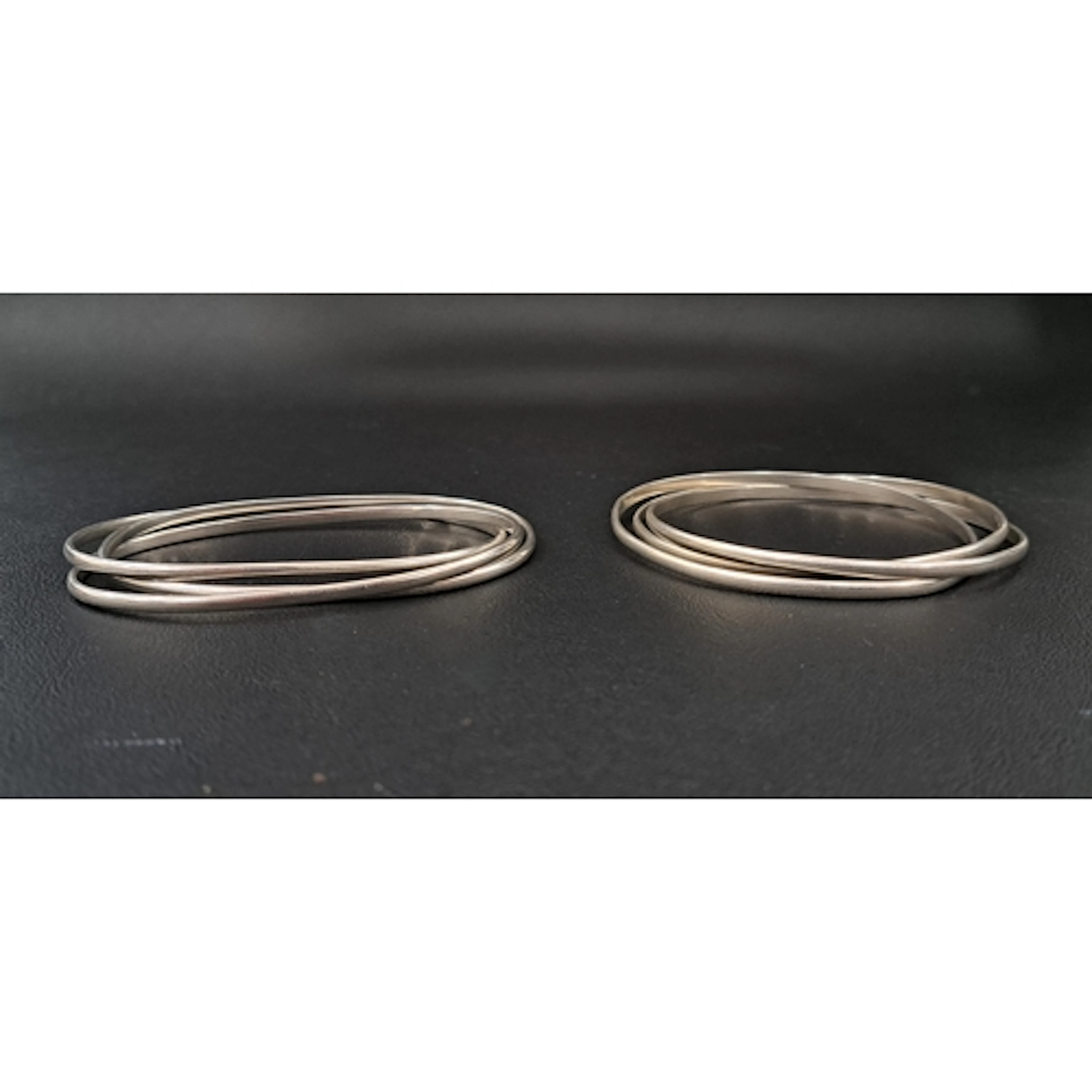 TWO TRIPLE ENTWINED SILVER BANGLES total weight approximatel...