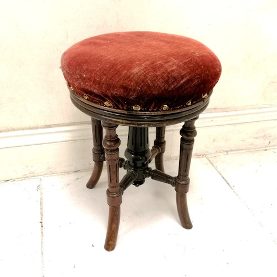 Antique revolving adjustable piano stool with red velvet sea...