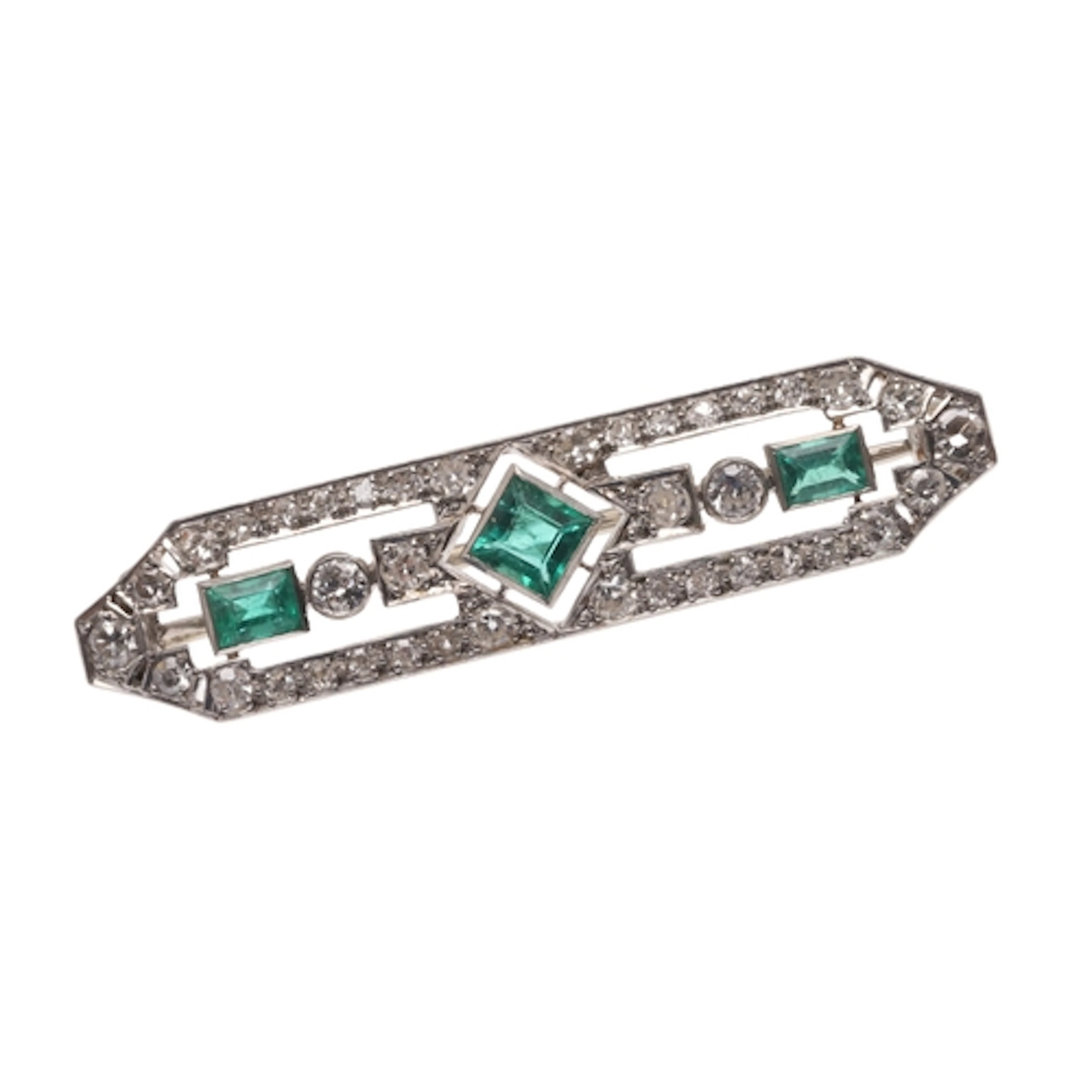 AN EMERALD AND DIAMOND BROOCH. of openwork design, mounted w...