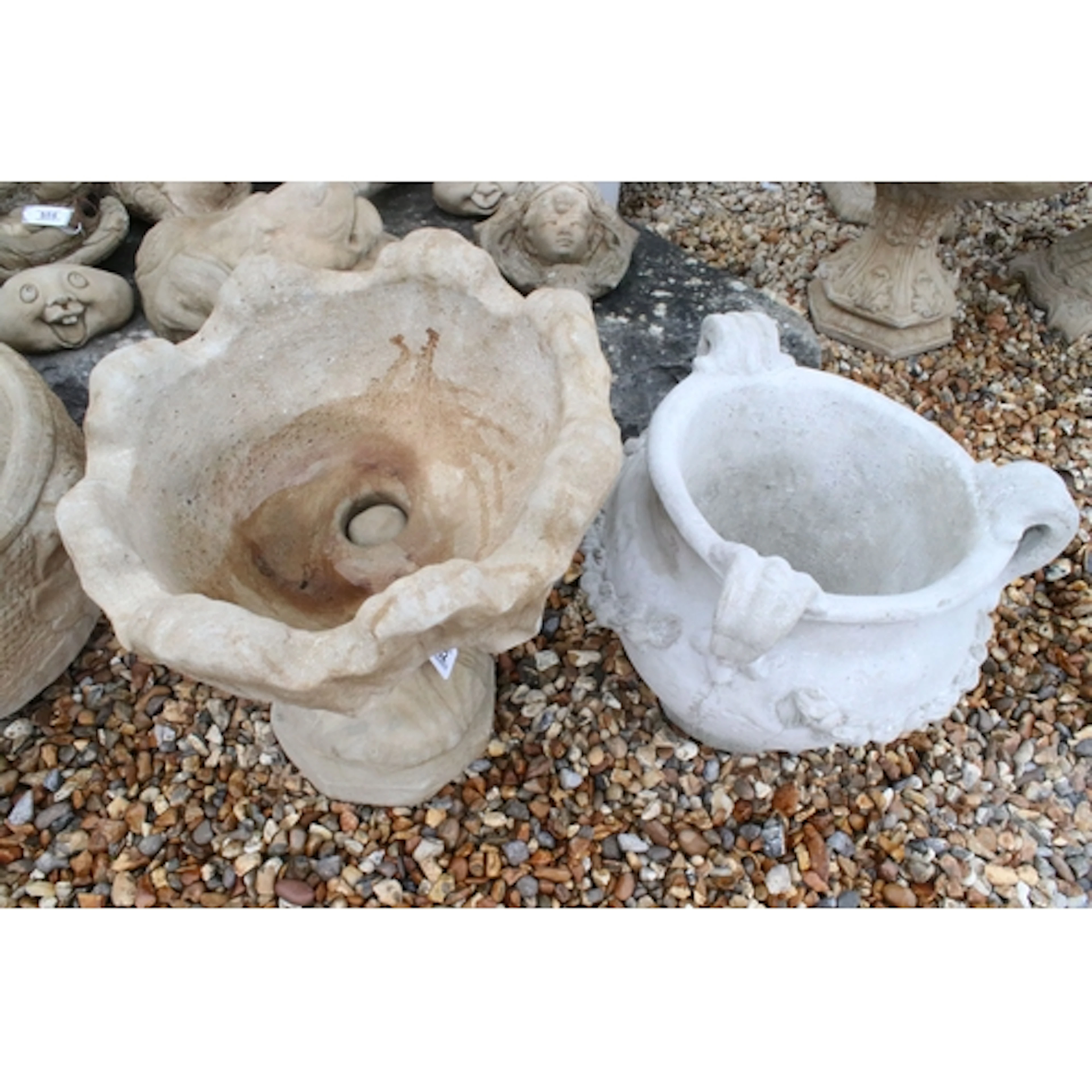 Reconstituted stone three handled urn, having foliate swags ...