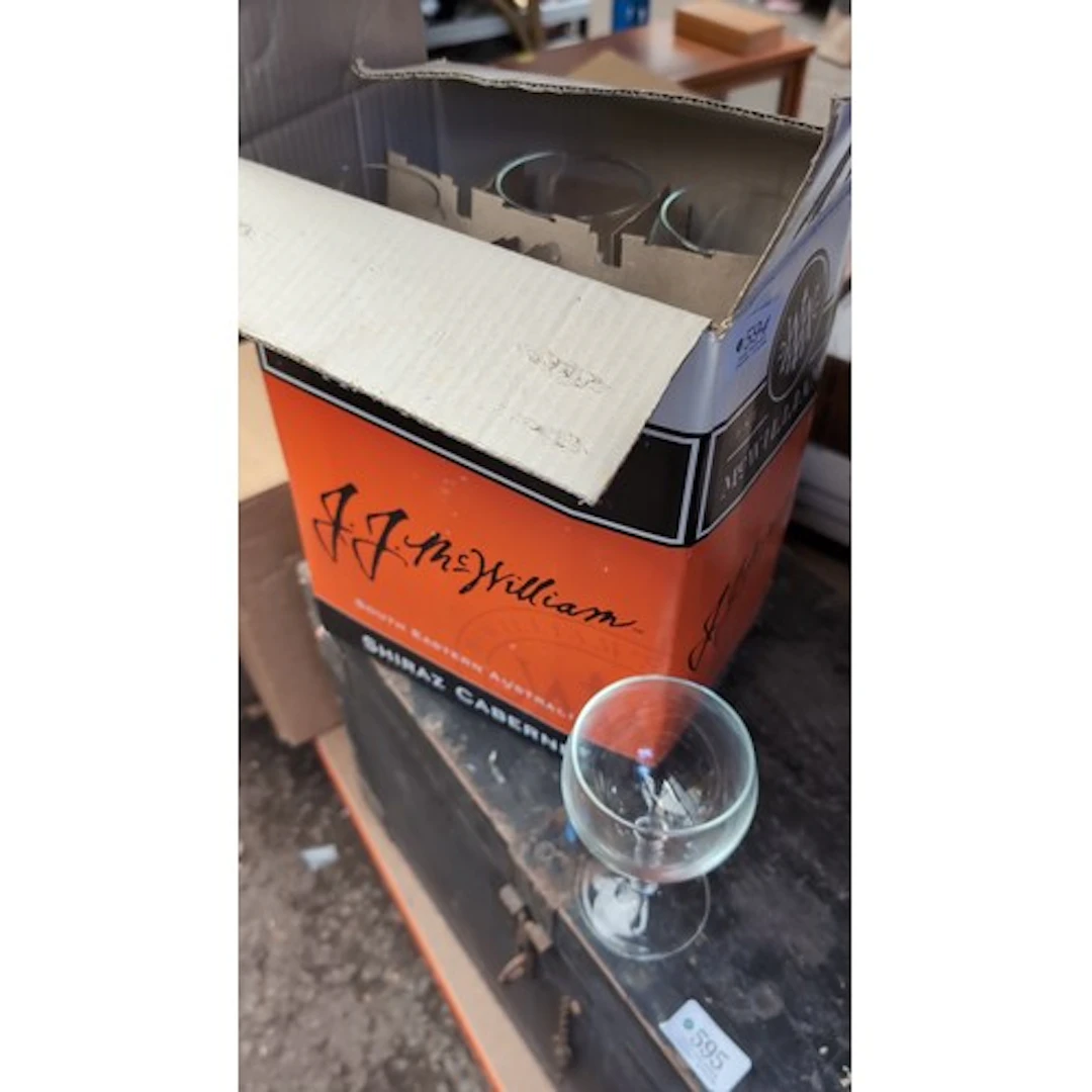 A group of clear glass wine glasses with rounded bowls, shor...