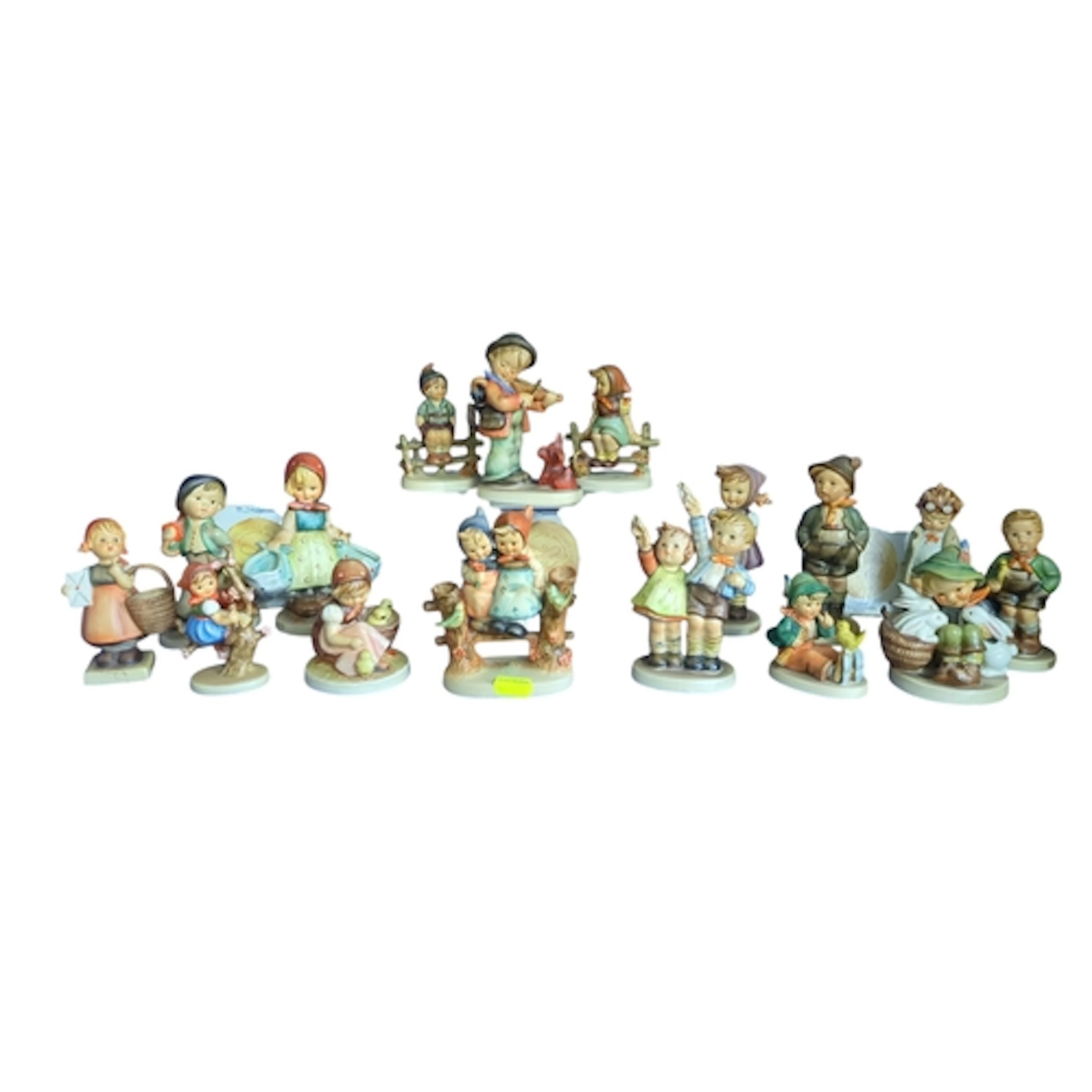 A collection of Goebel M. I. Hummel porcelain figures depict...