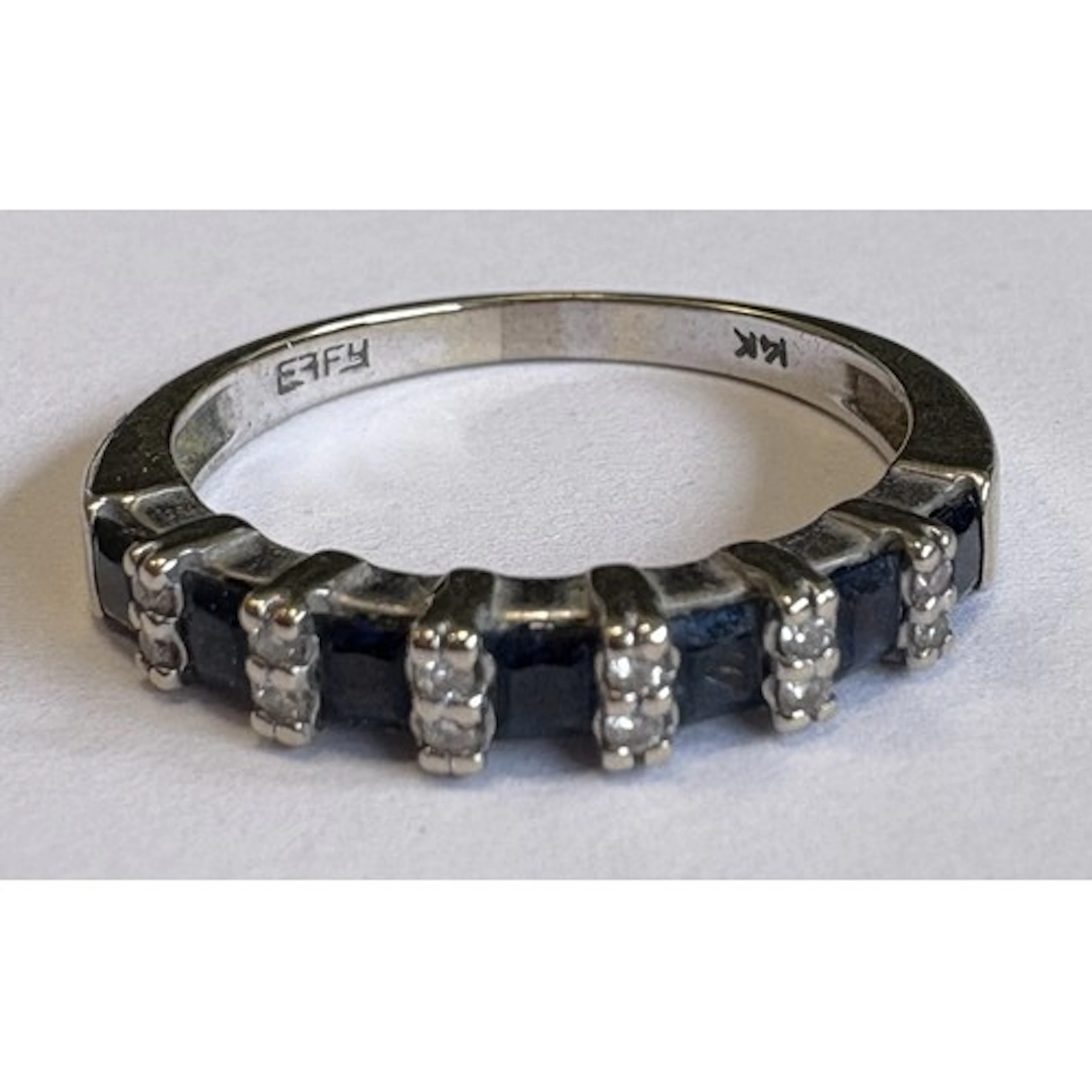 A 14 carat gold sapphire and diamond half hoop eternity ring...