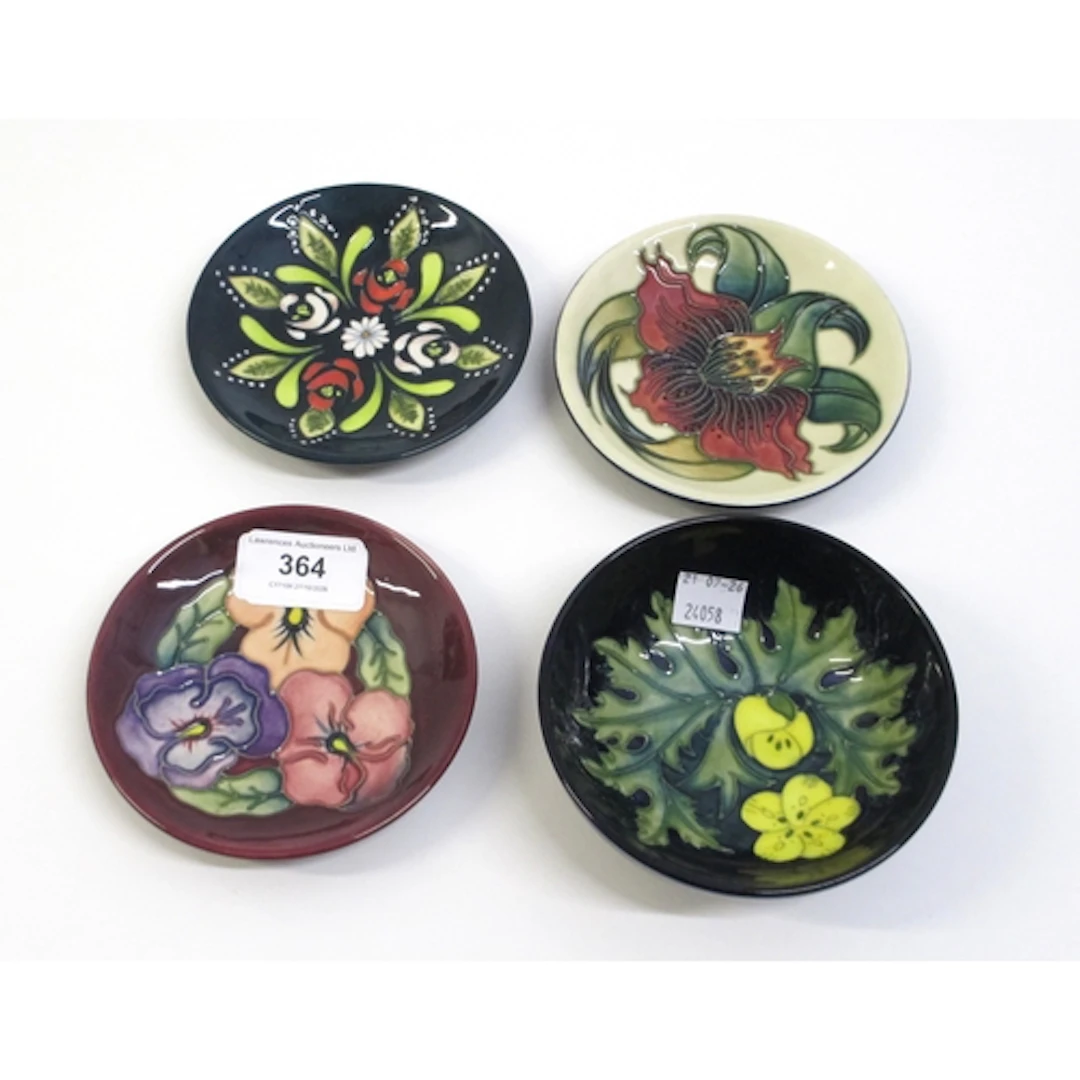 Group of four miniature Moorcroft floral tube line decorated...