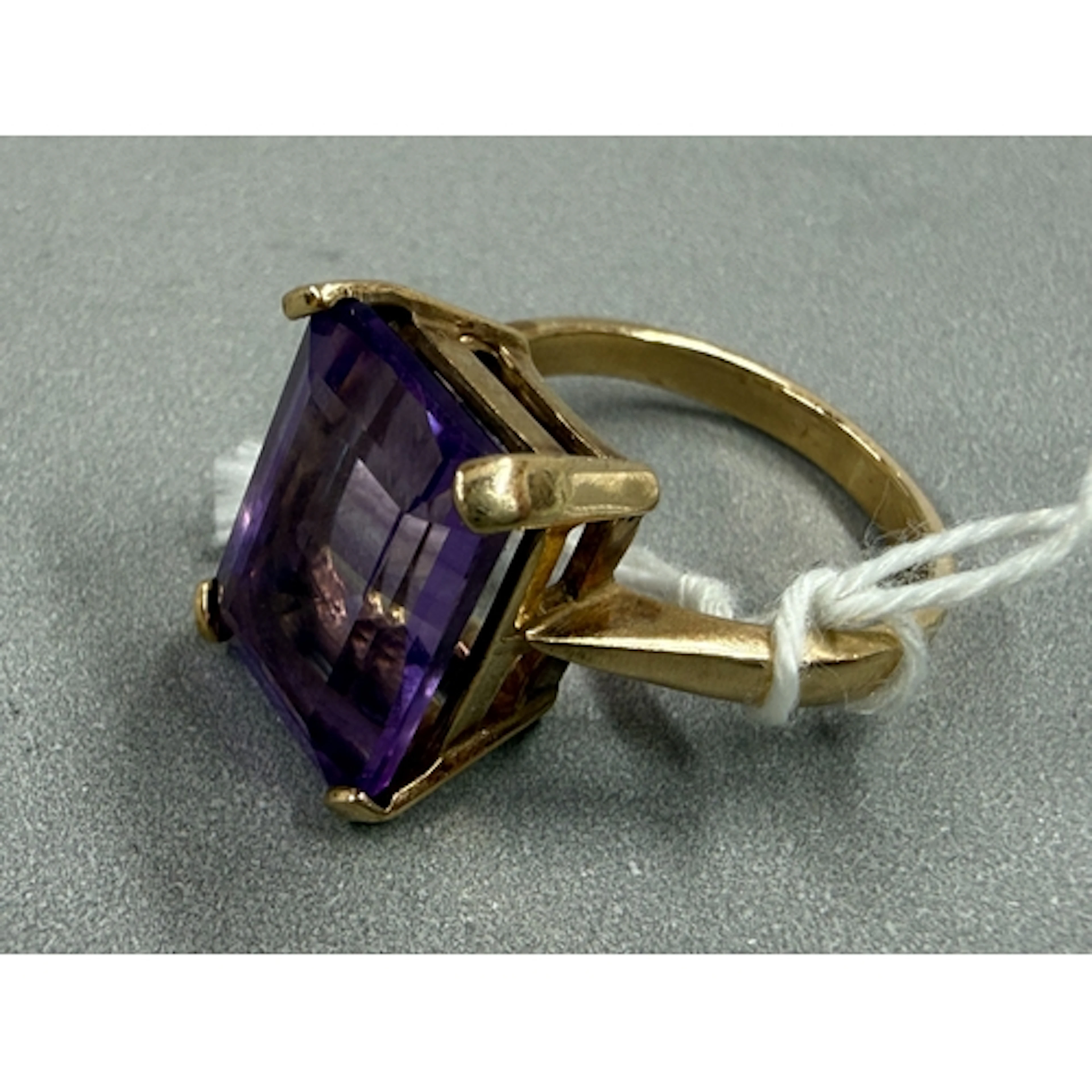Jewellery: a 9ct yellow gold ring set a single emerald cut a...
