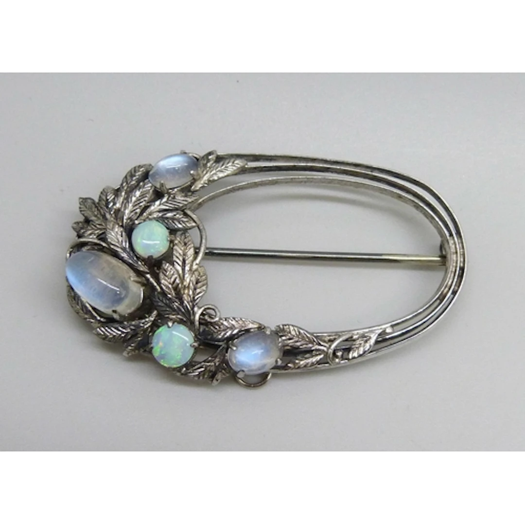 An Arts & Crafts white metal floral design brooch set with o...