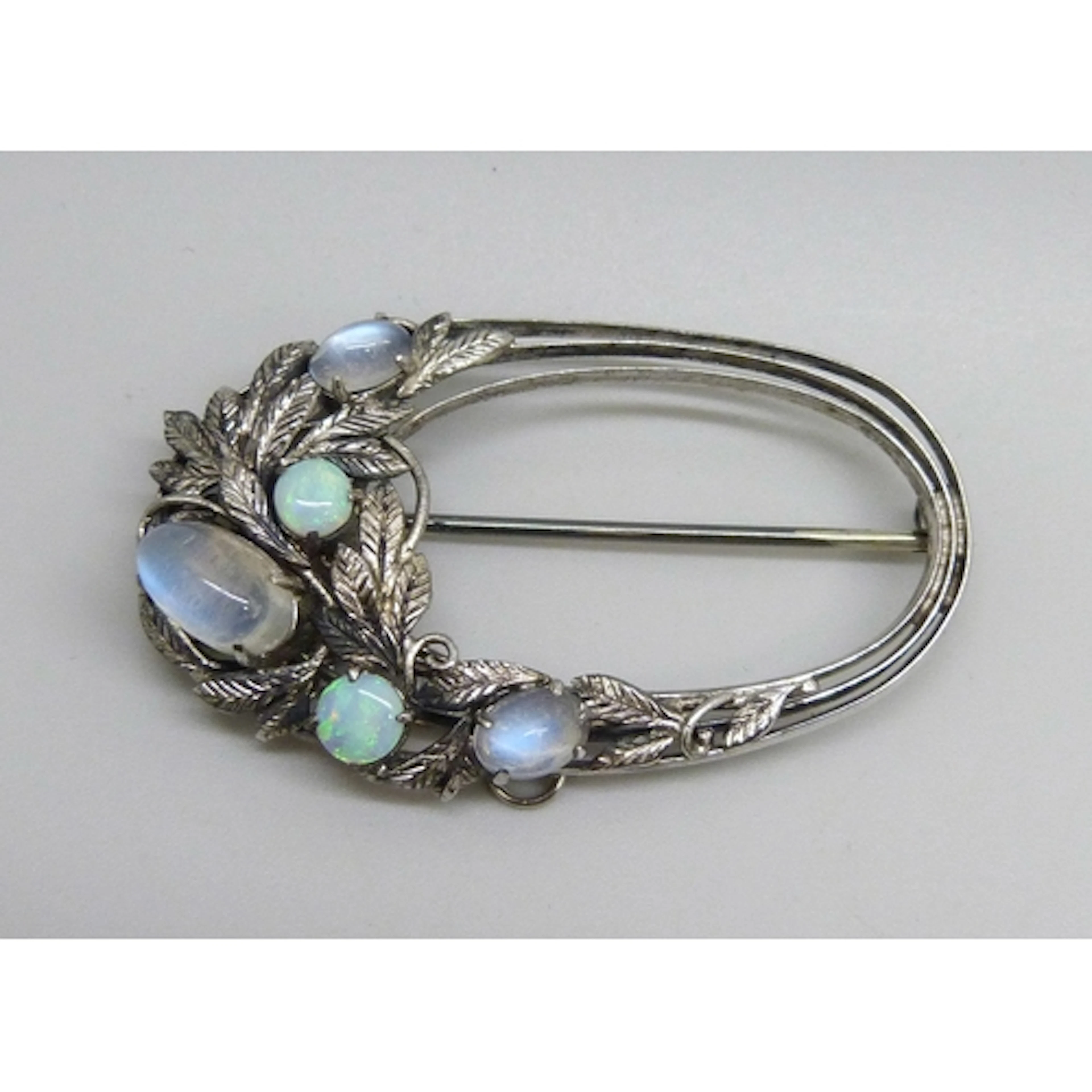 An Arts & Crafts white metal floral design brooch set with o...