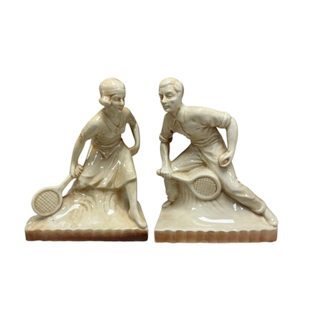 A pair of Art Deco style pottery tennis player bookends, hei...