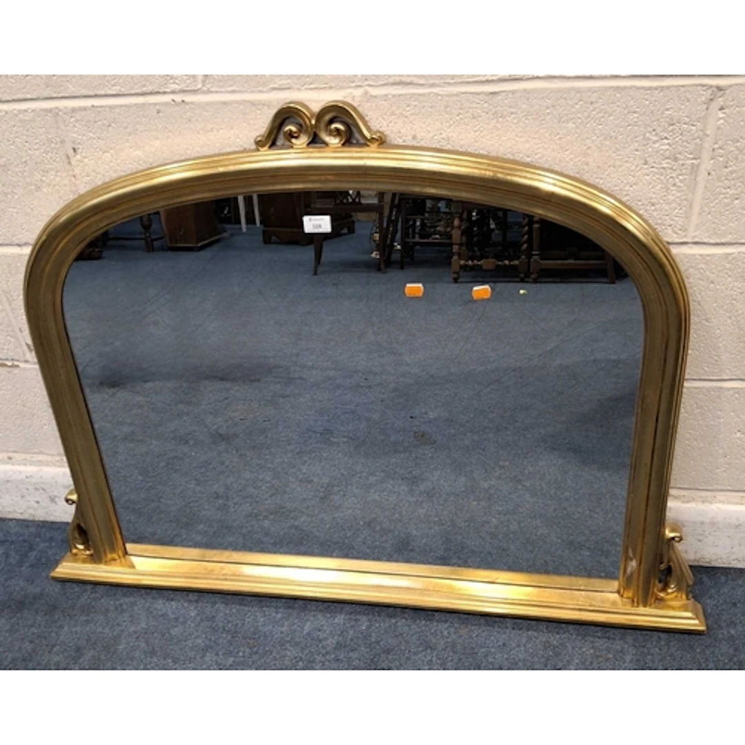 A MODERN GILT FRAME OVERMANTEL MIRROR, with a scrolled crest...