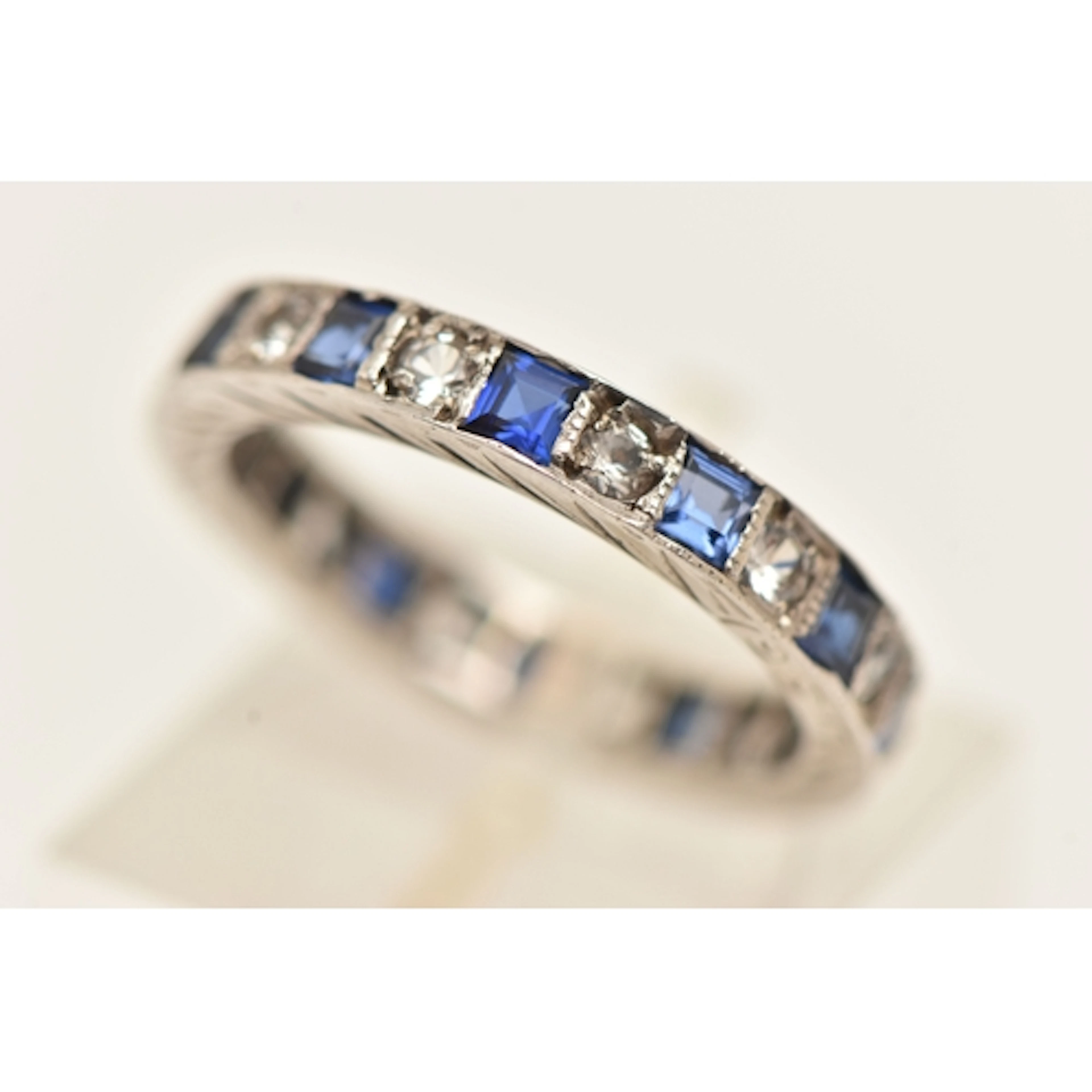 A WHITE METAL GEM SET FULL ETERNITY BAND RING, set with alte...