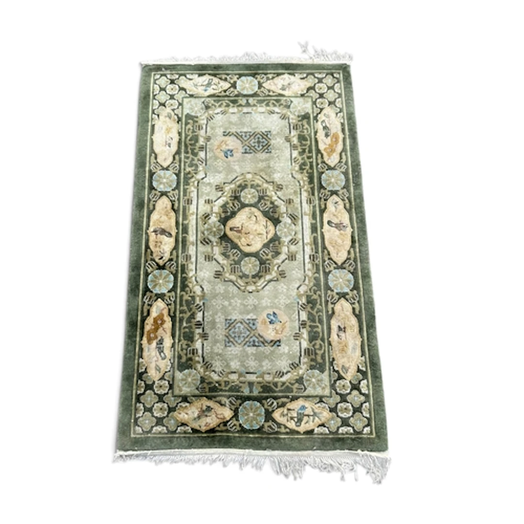 A CHINESE SILK RUG, WITH CENTRAL MEDALLION AGAINST A GREEN G...
