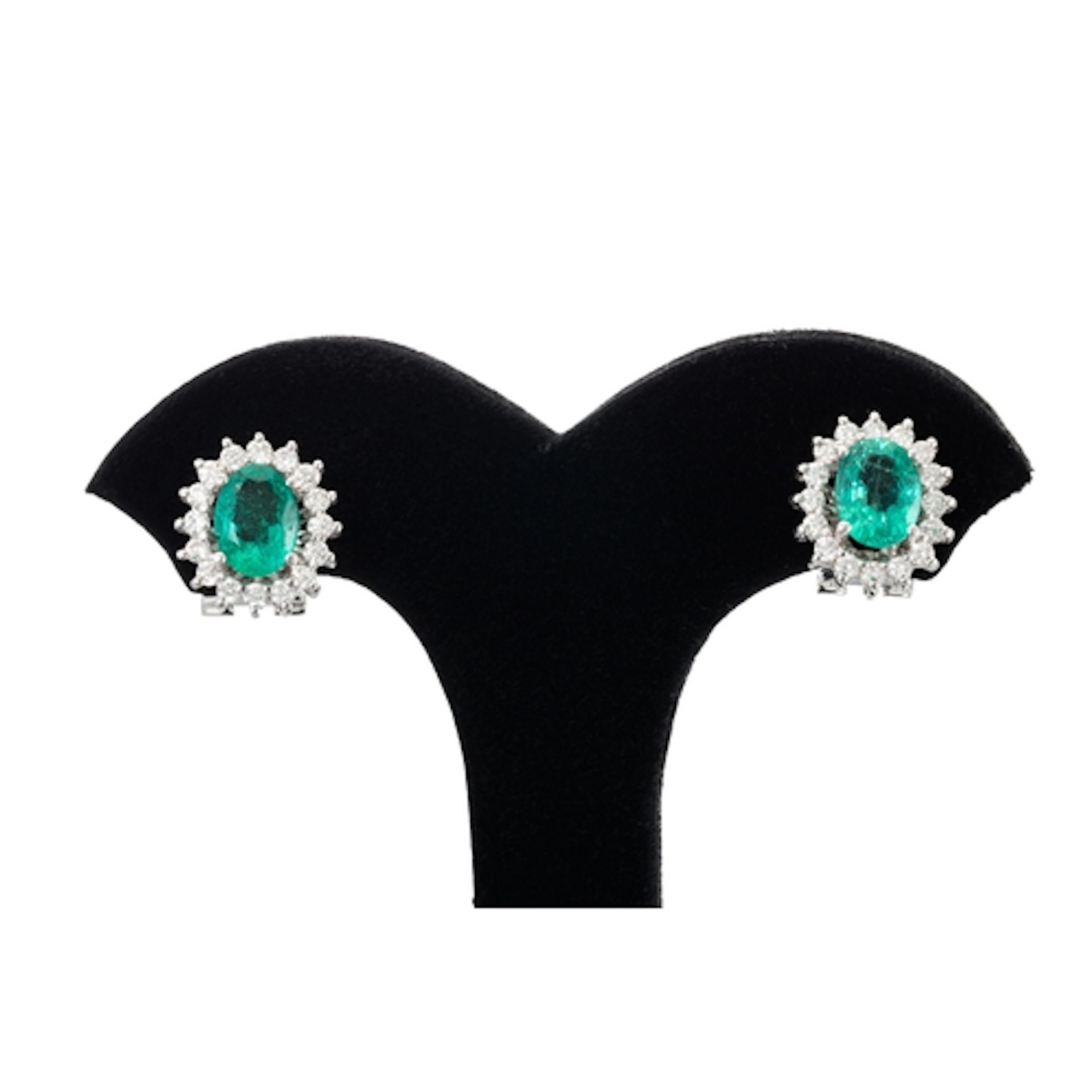 A PAIR OF EMERALD AND DIAMOND CLUSTER EARRINGS, the oval eme...