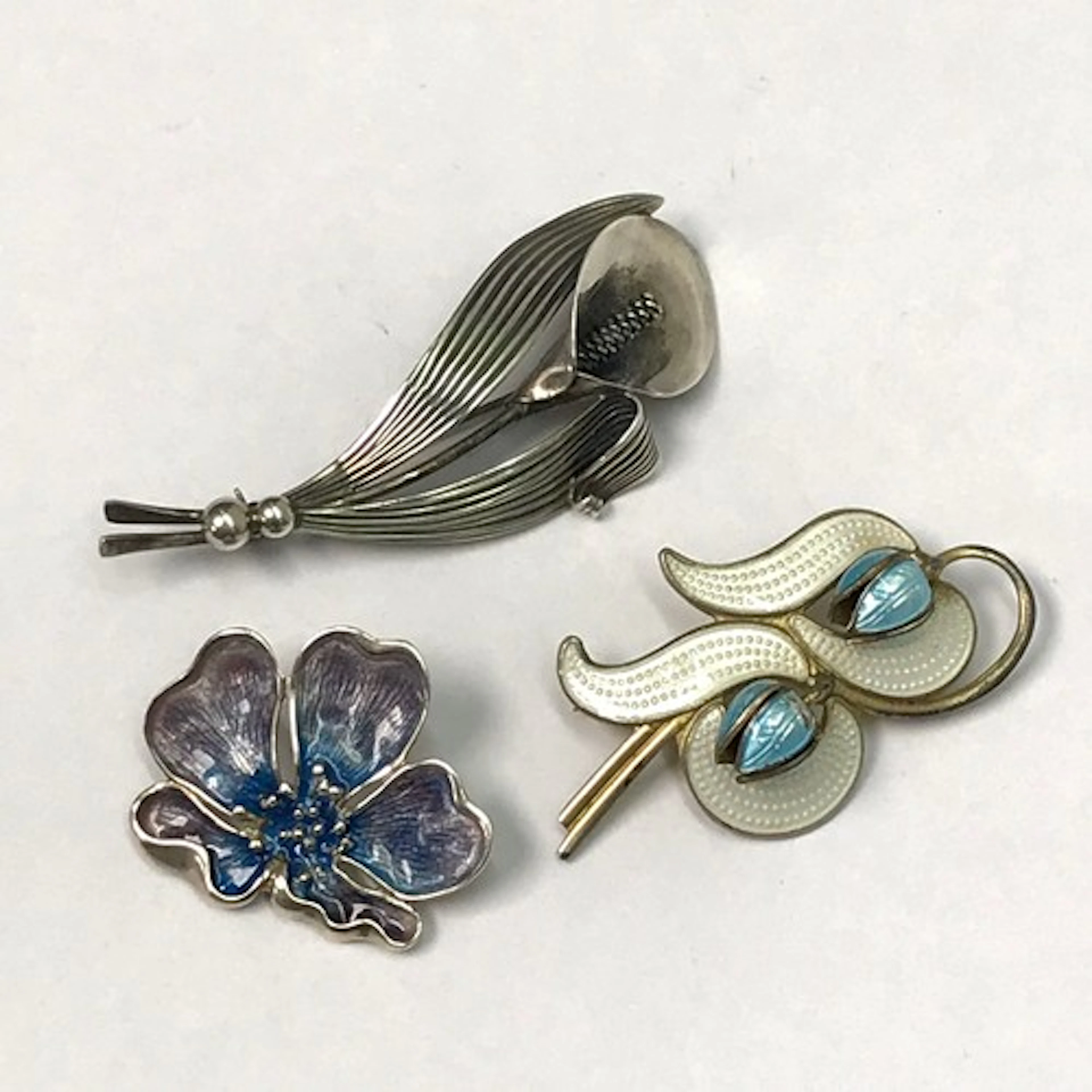 A Scandinavian flowers and leaves motif brooch, gilt white m...