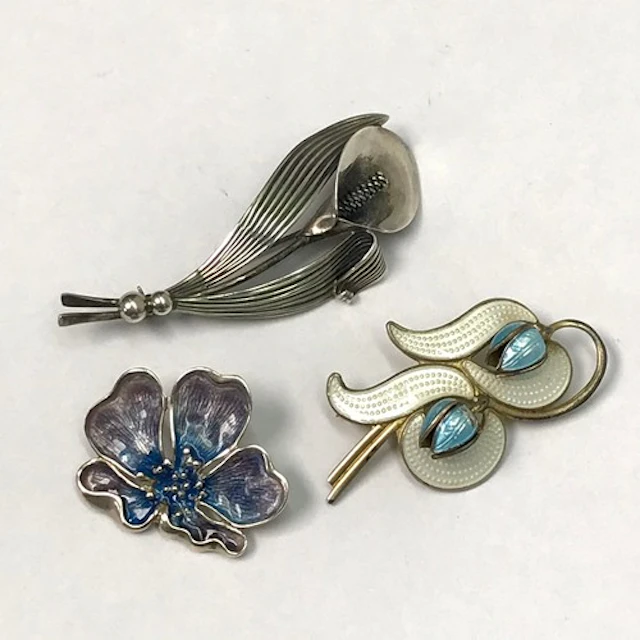 A Scandinavian flowers and leaves motif brooch, gilt white m...