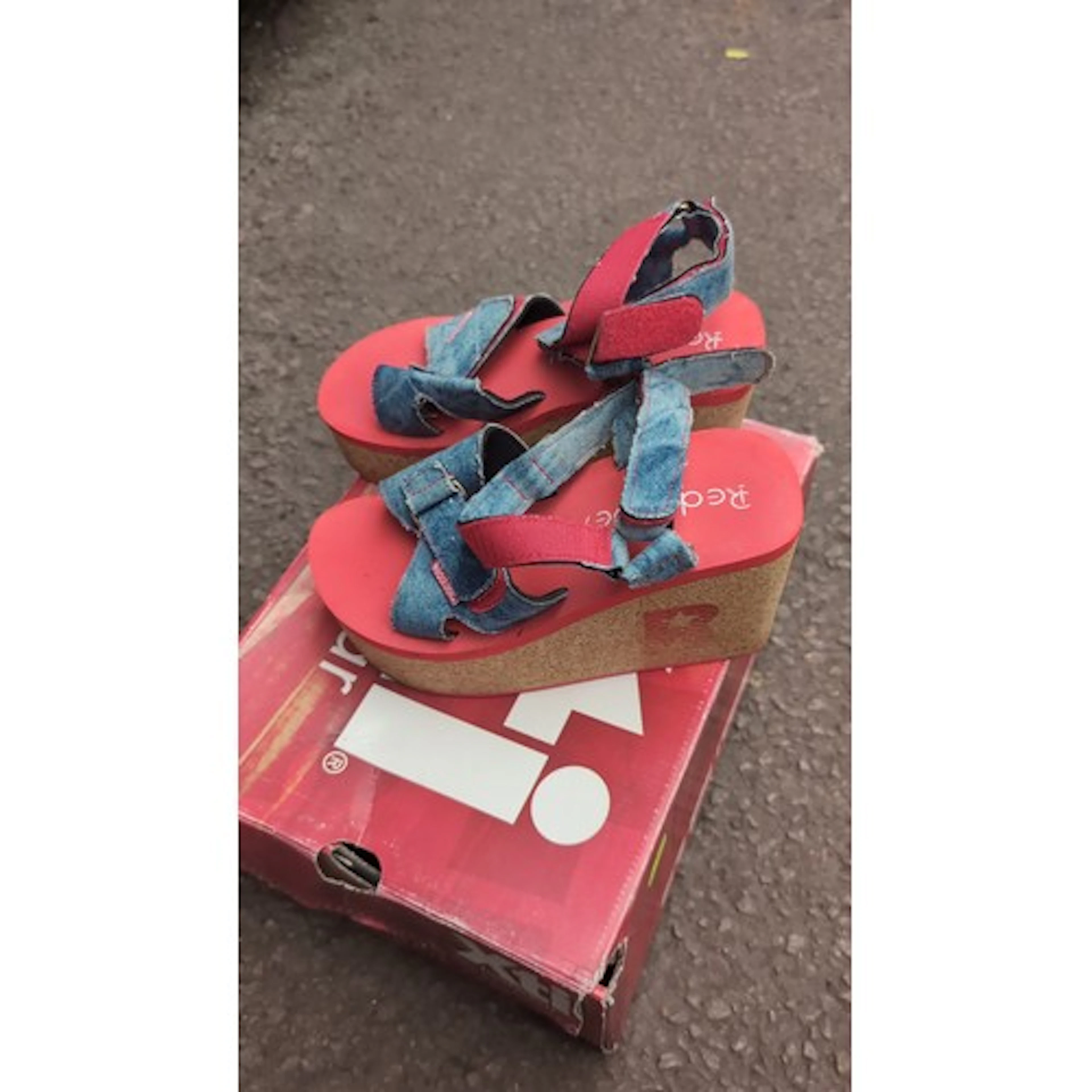 A pair of platform wedge sandals with red moulded footbeds a...