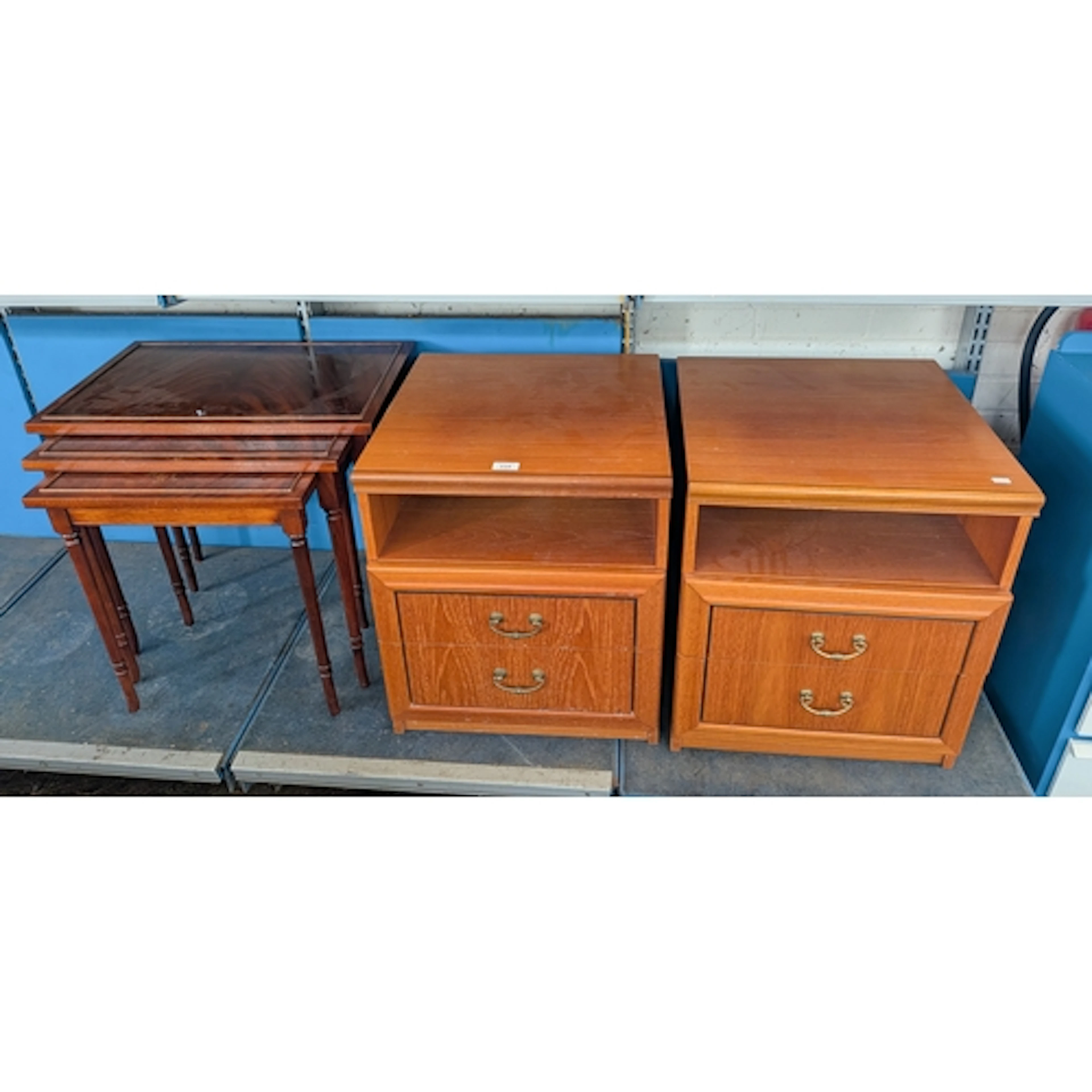 A pair of teak two drawer bedside cabinets with brushing sli...