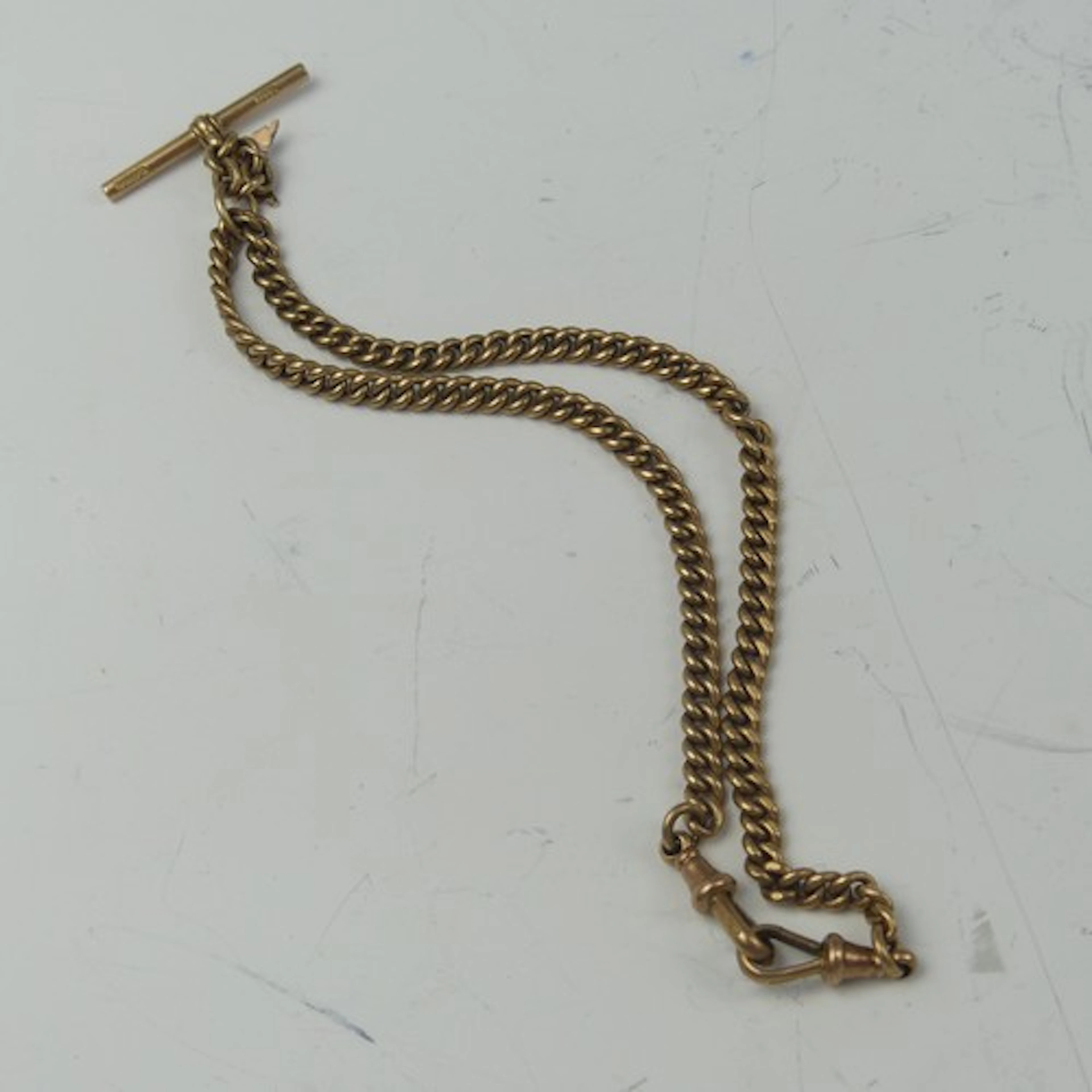 A 9ct rose gold curb link Watch Chain, with a dog clip at ei...
