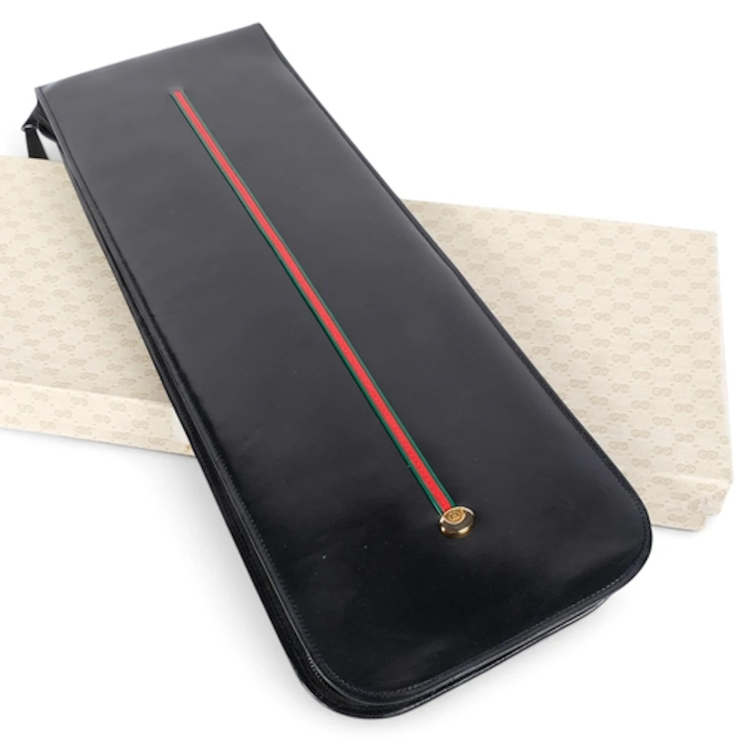 A gentleman's Gucci leather tie holder, with a Gucci silk ti...