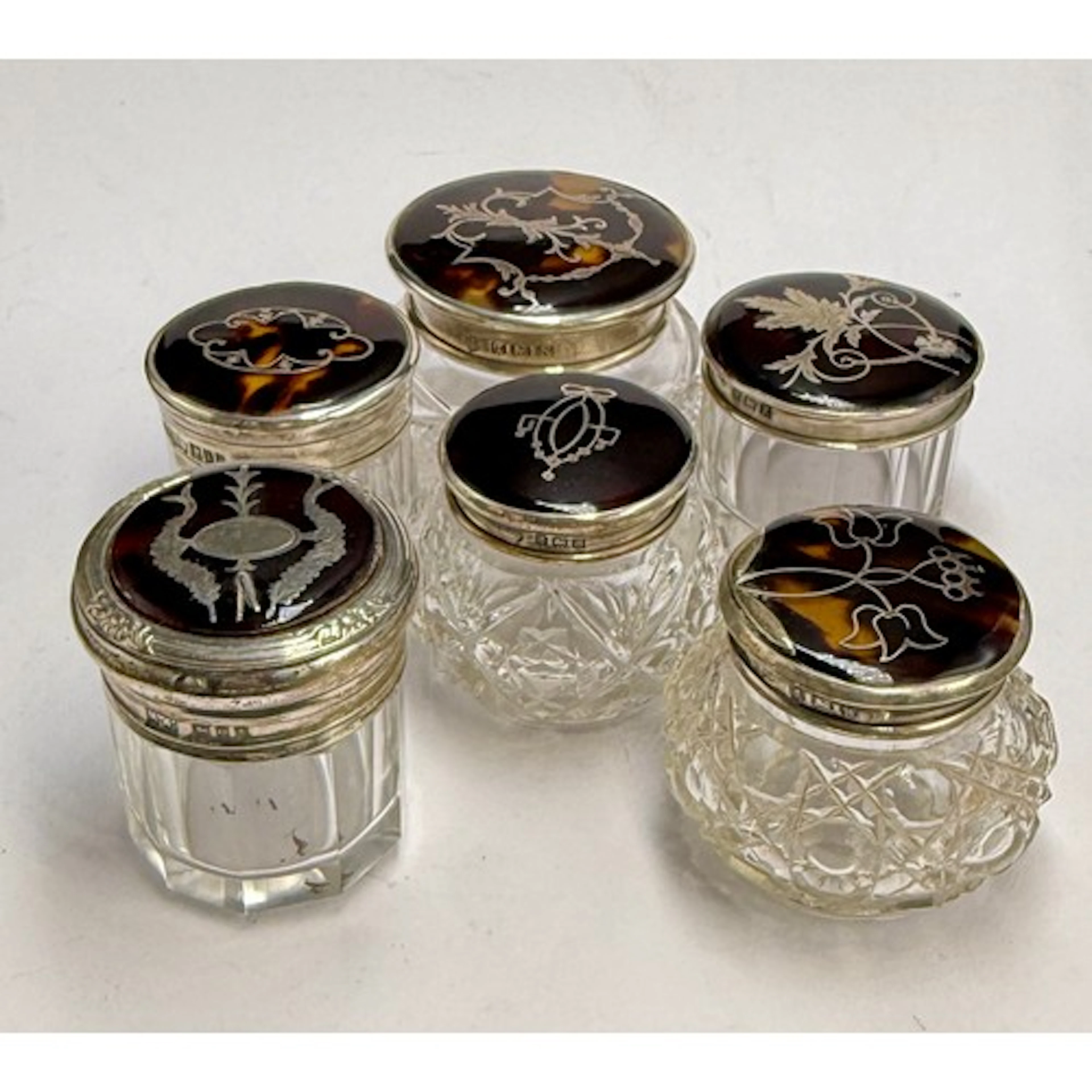 Six glass jars with hallmarked silver and tortoiseshell piqu...