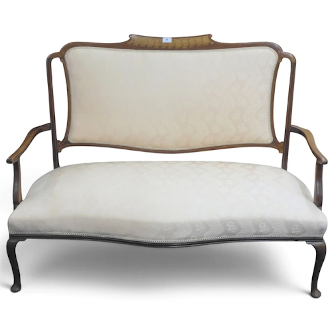 An Edwardian walnut framed parlour settee upholstered in off...