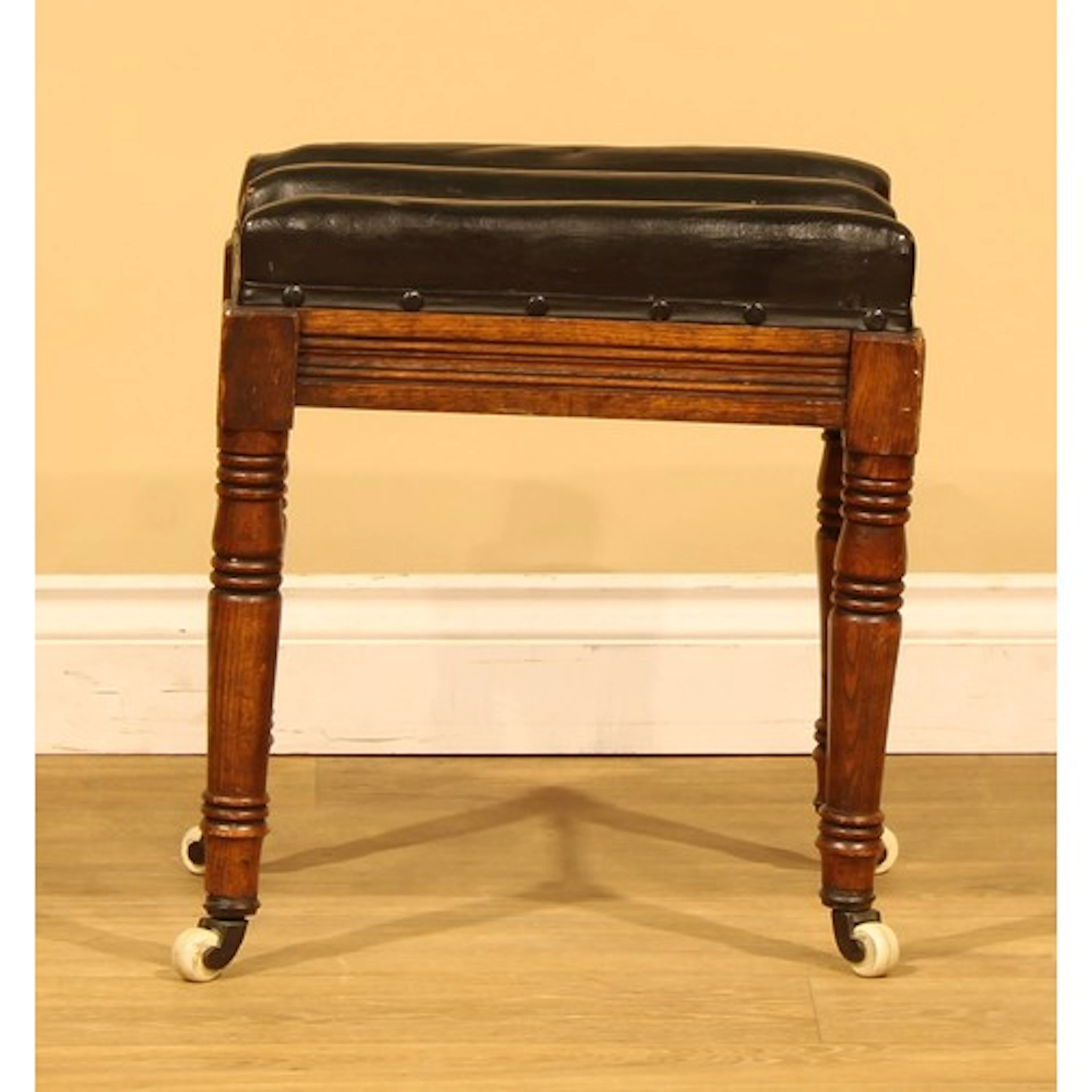 A Victorian ash stool, stuffed-over channeled seat, ring-tur...
