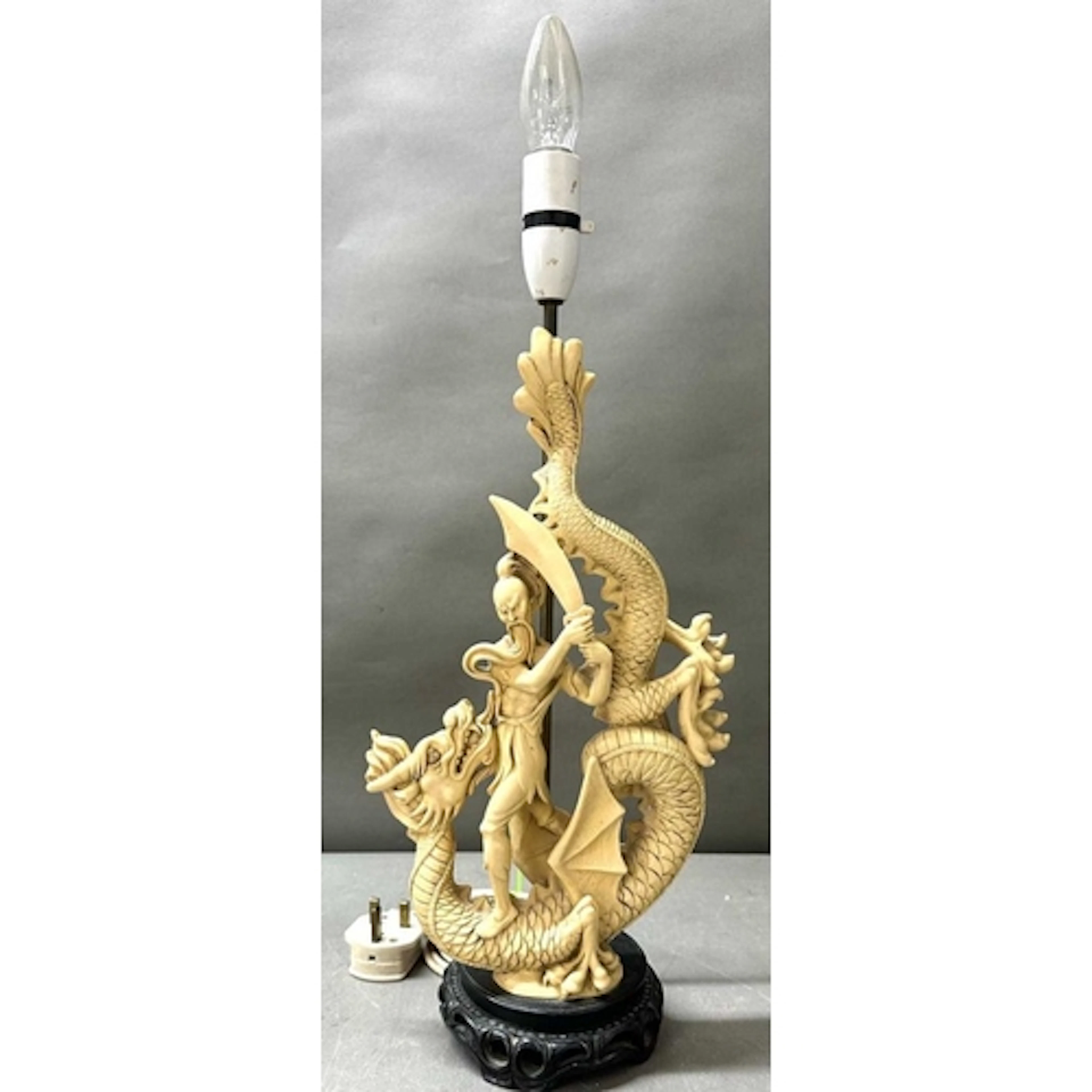 A table lamp featuring an Asian dragon slayer sculpture (58c...