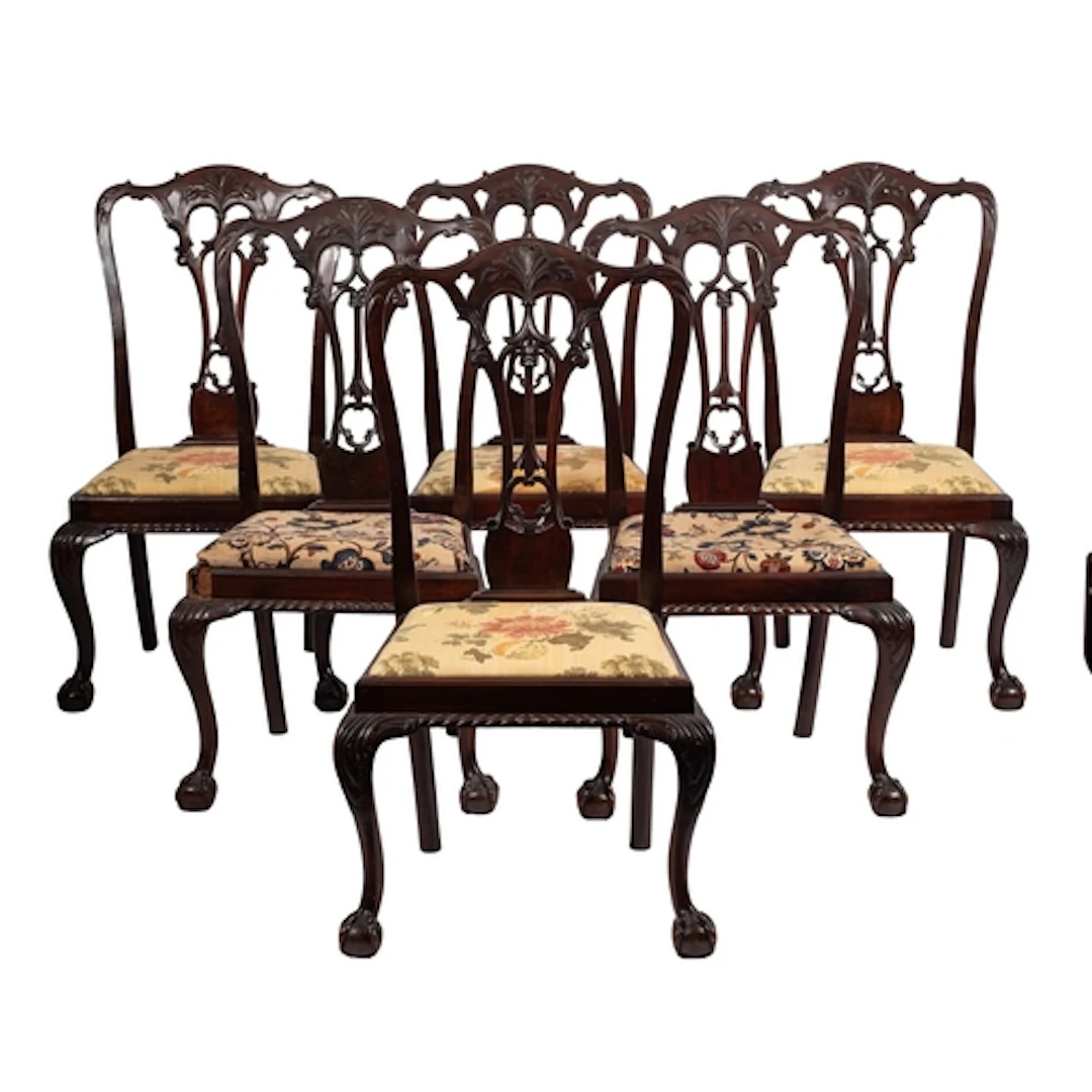 A set of twelve carved and stained hardwood dining chairs in...