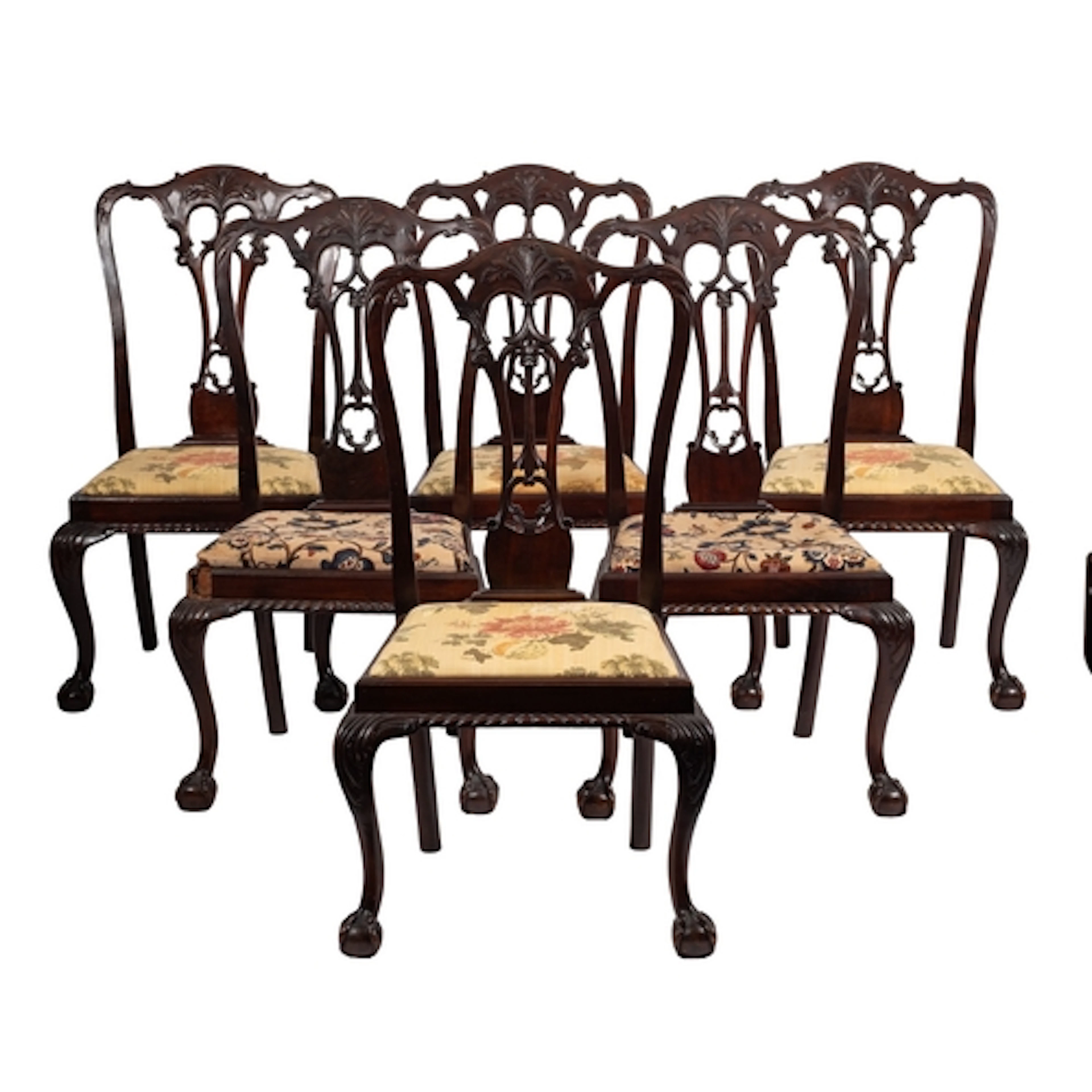 A set of twelve carved and stained hardwood dining chairs in...