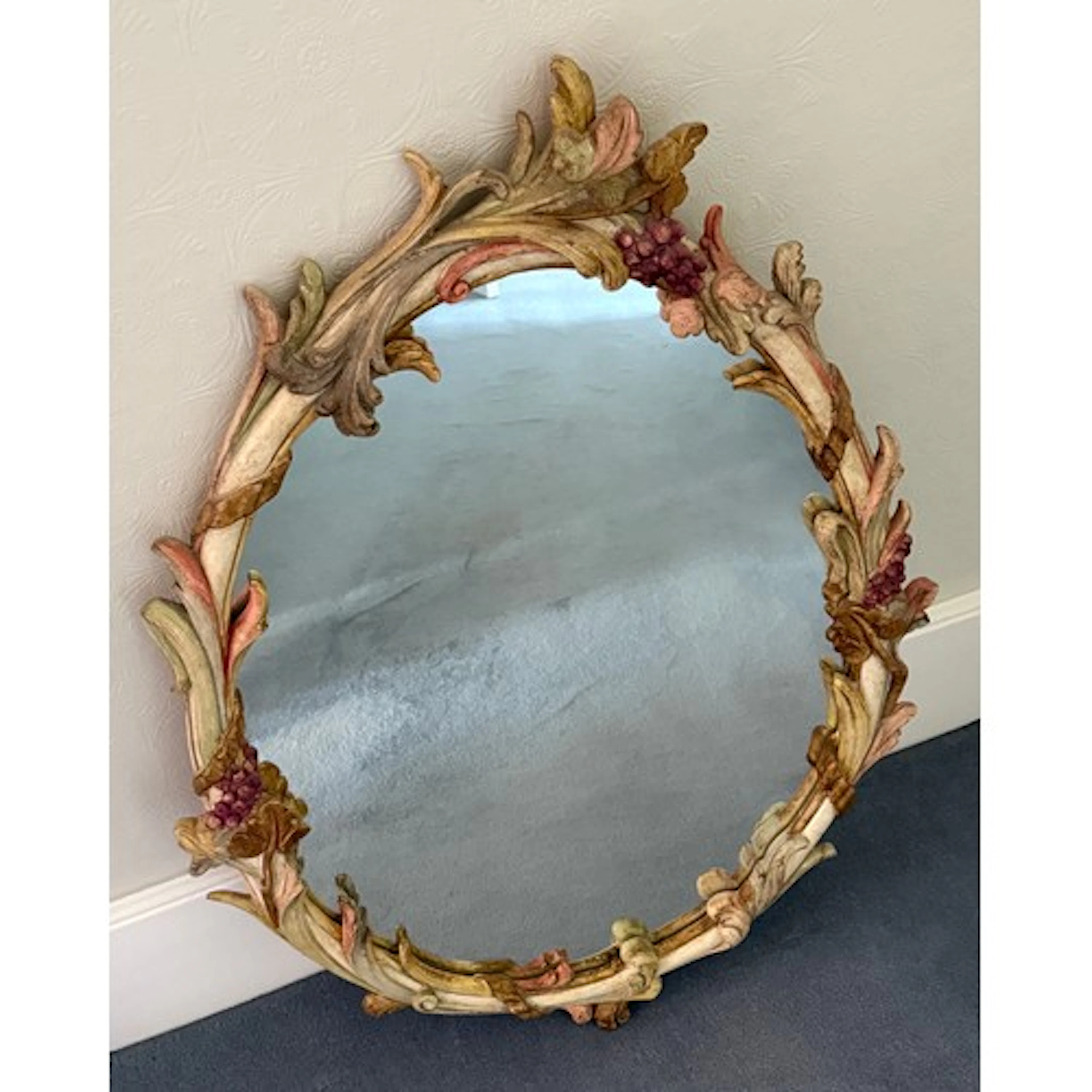 A decorative oval wooden framed mirror. 90 x 62cm.