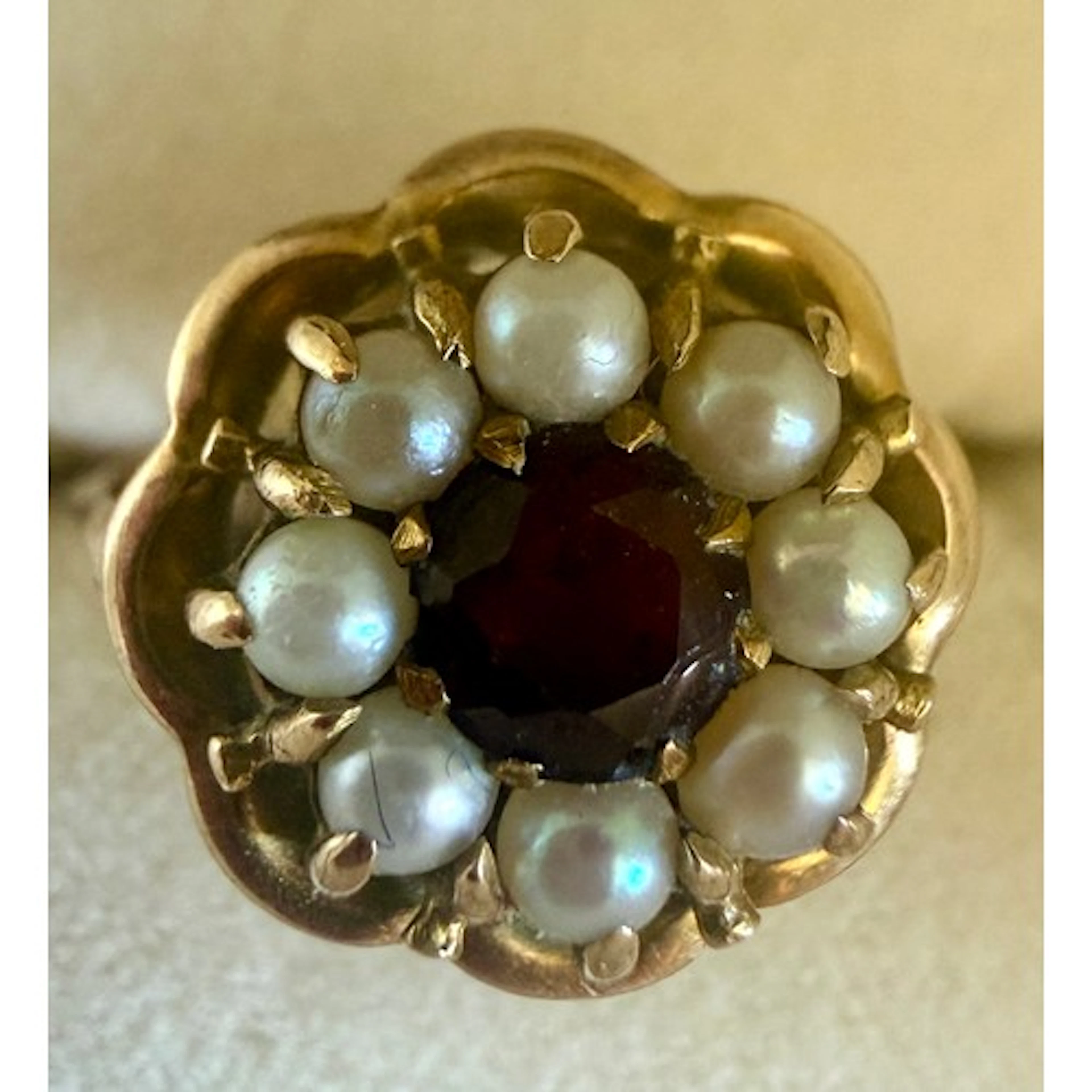 A 9 carat gold cluster ring set with garnets and seed pearls...