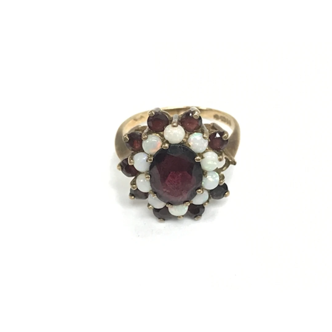 A 9ct gold ring set with garnets and Opal. Missing 1 stone, ...
