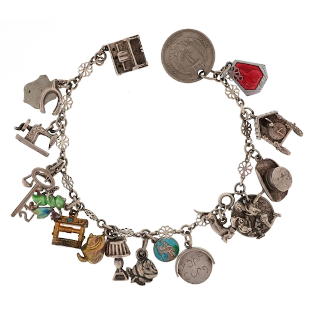 Broken white metal charm bracelet with a selection of mostly...