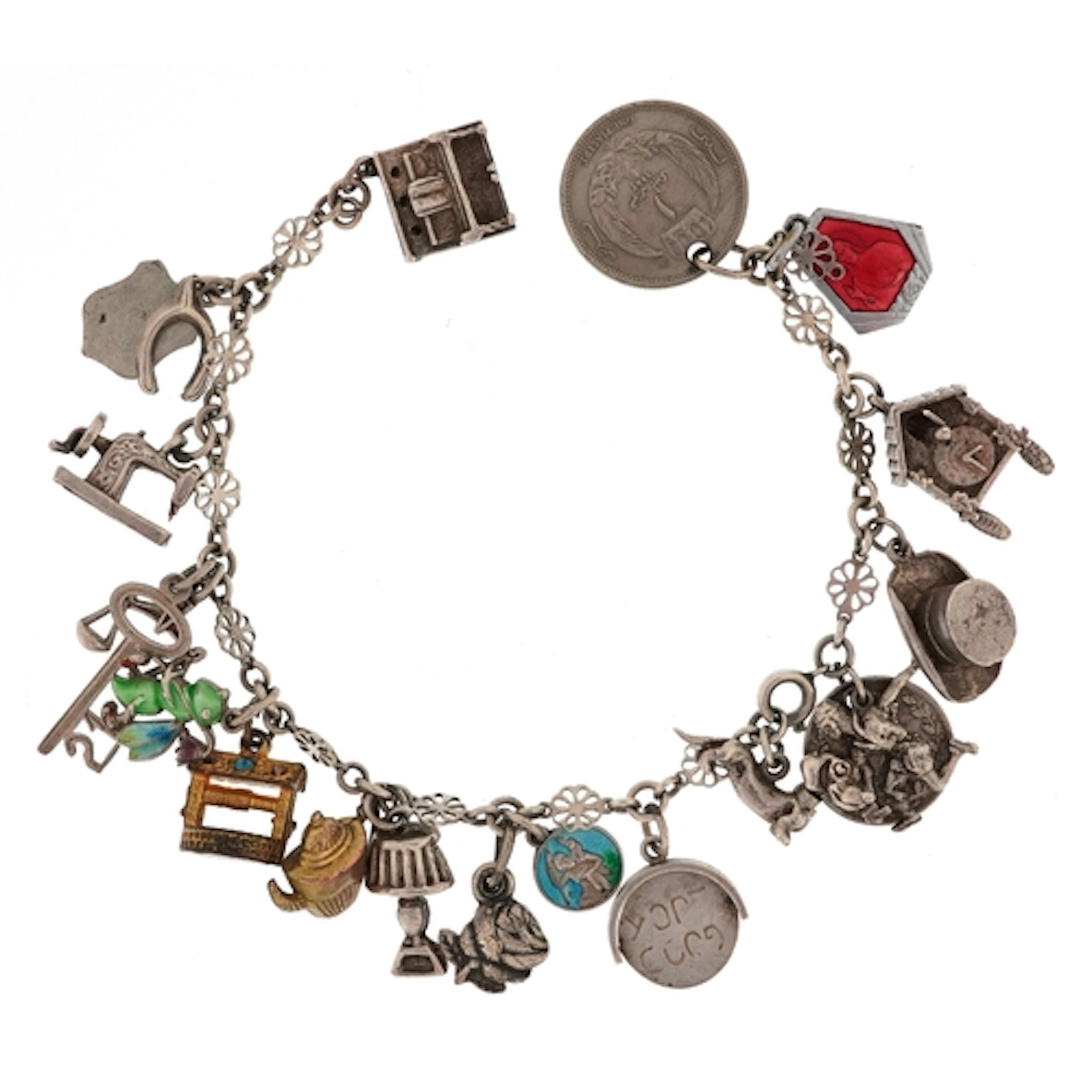 Broken white metal charm bracelet with a selection of mostly...