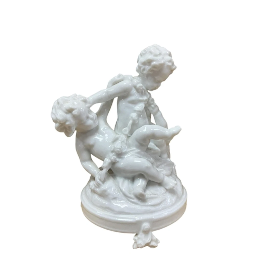 A Meissen white-glazed porcelain figure group of two playful...