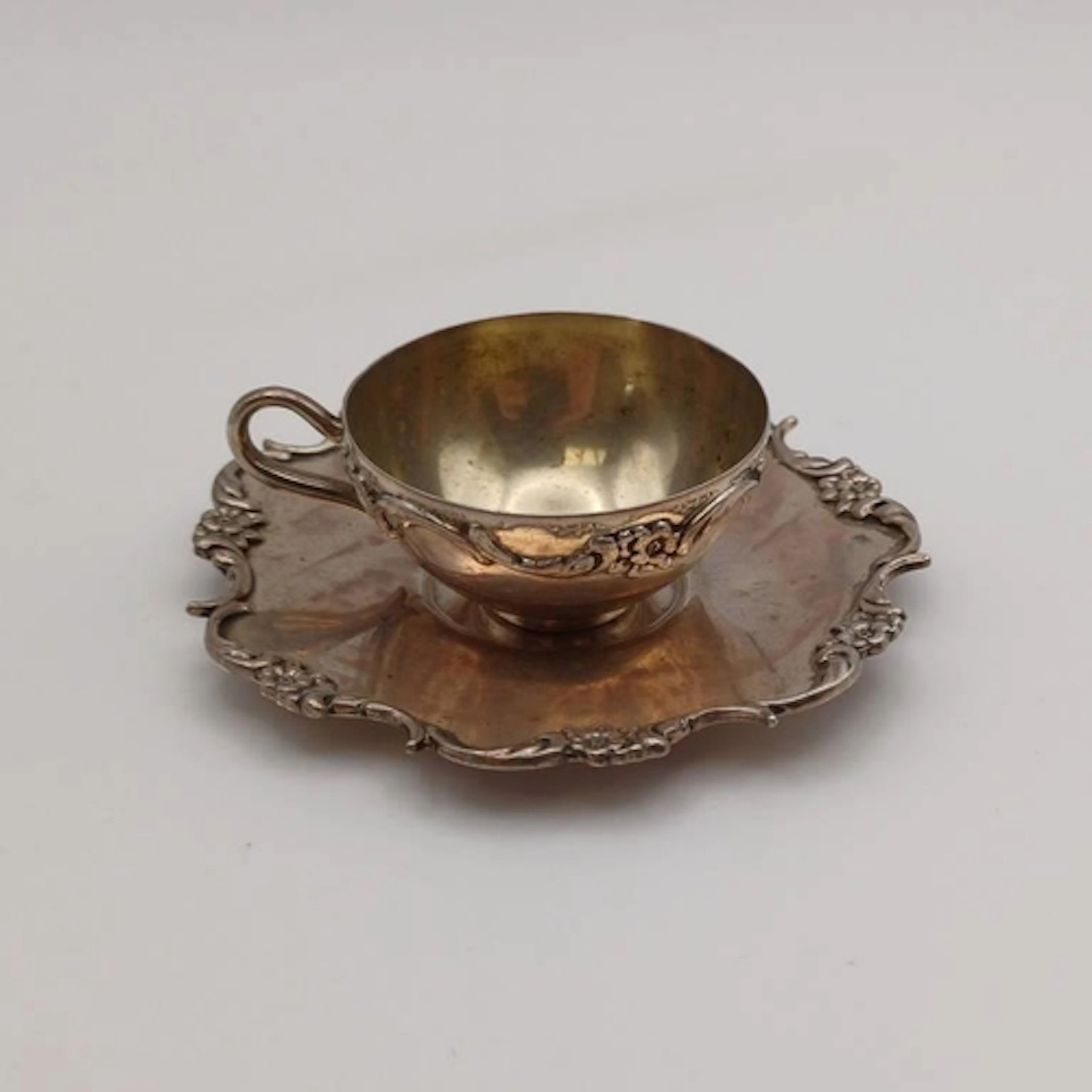 AN AMERICAN SILVER MINIATURE CUP & SAUCER WITH EMBOSSED FLOR...