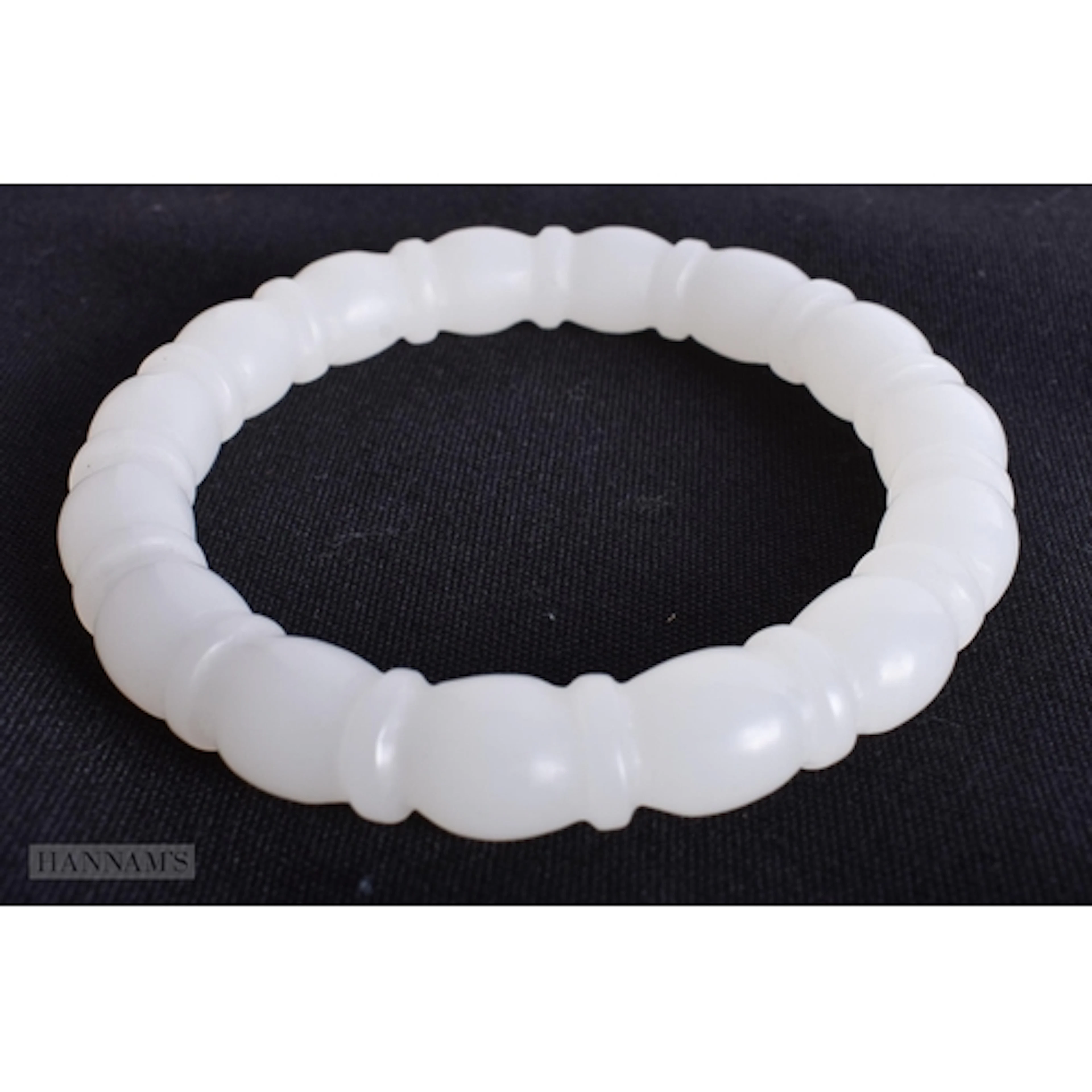 A CHINESE WHITE JADE RIBBED BANGLE. 6 cm internal diameter