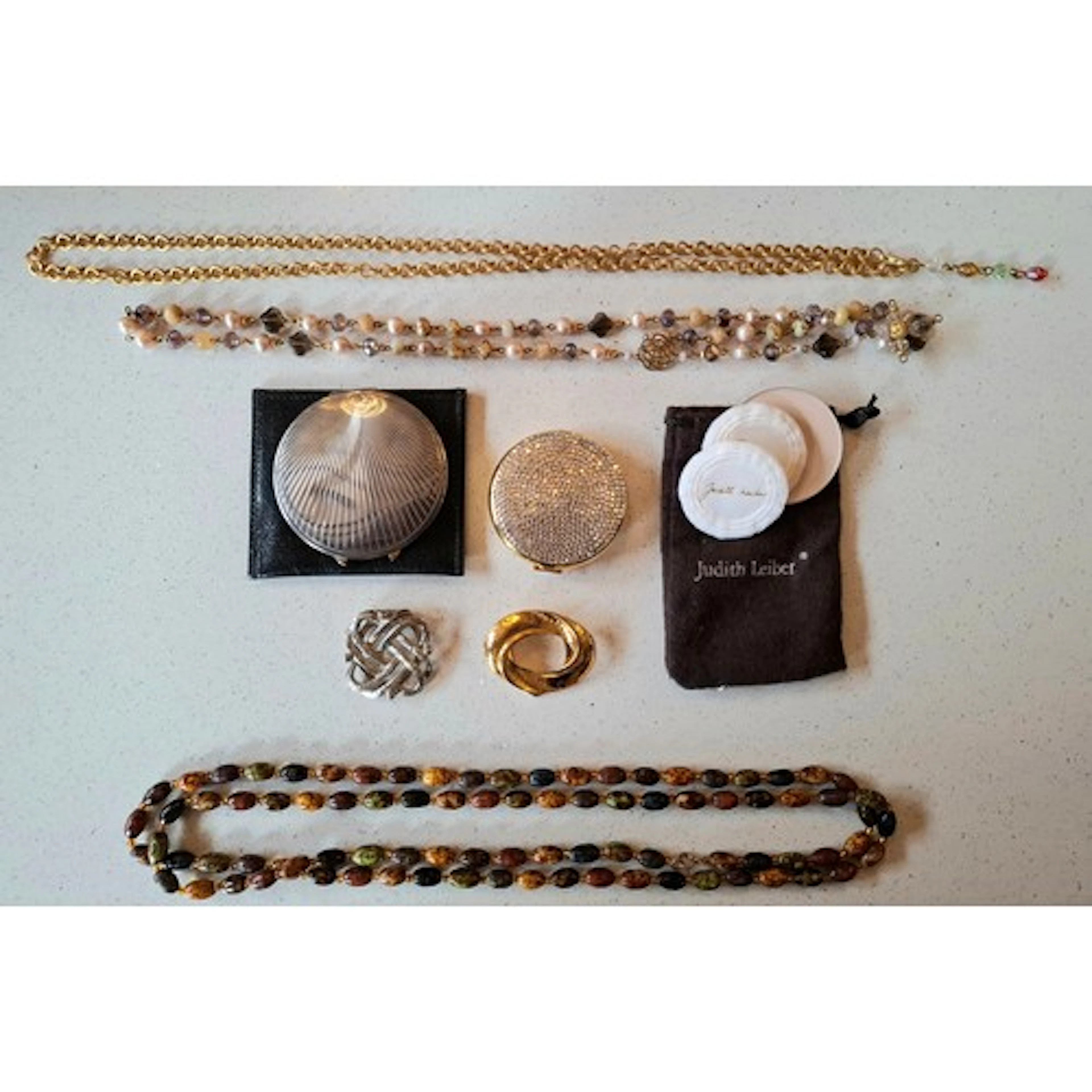 A silver compact, a Judith Leiber gold tone and crystal comp...