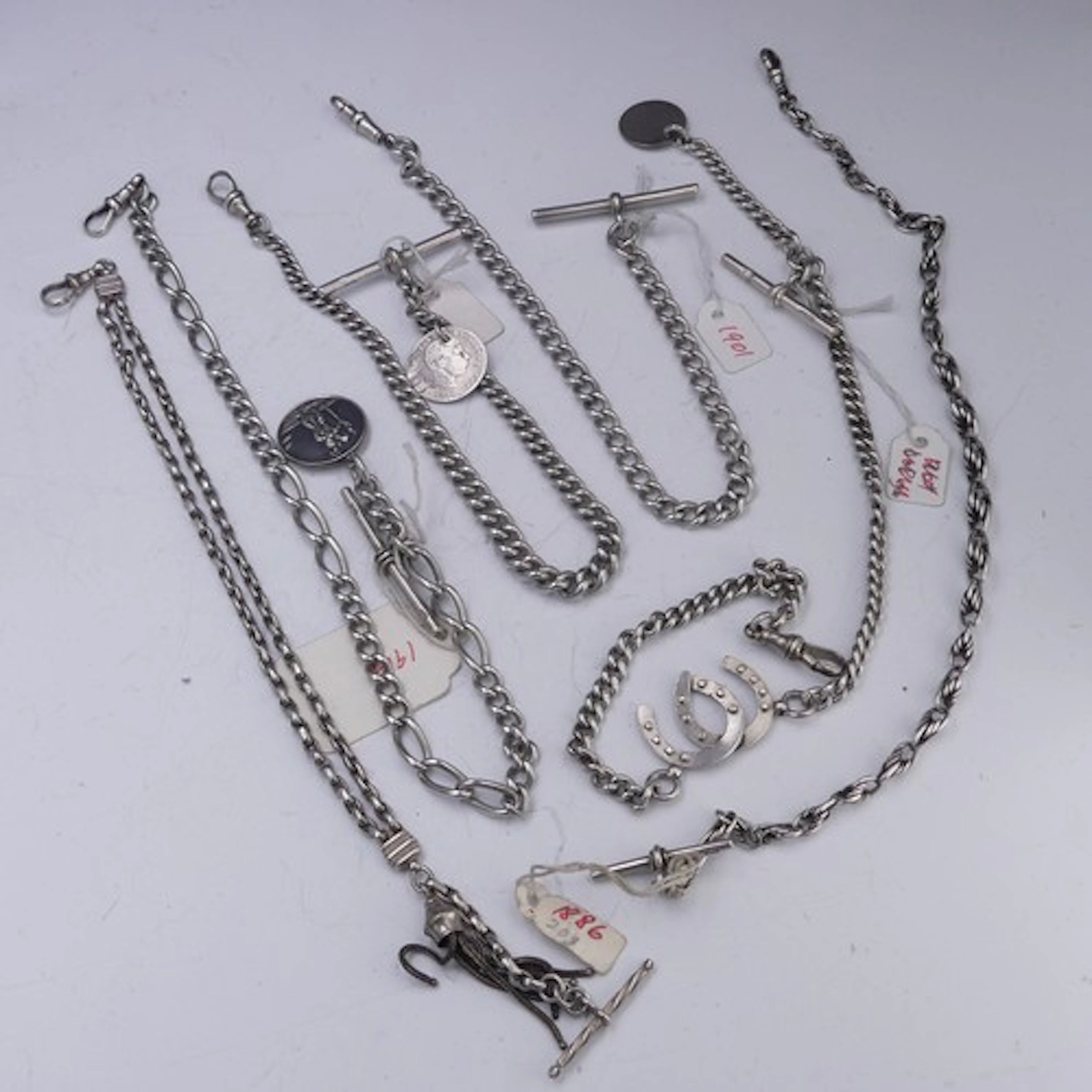 Six silver Watch Chains, two with coin fobs suspended, anoth...