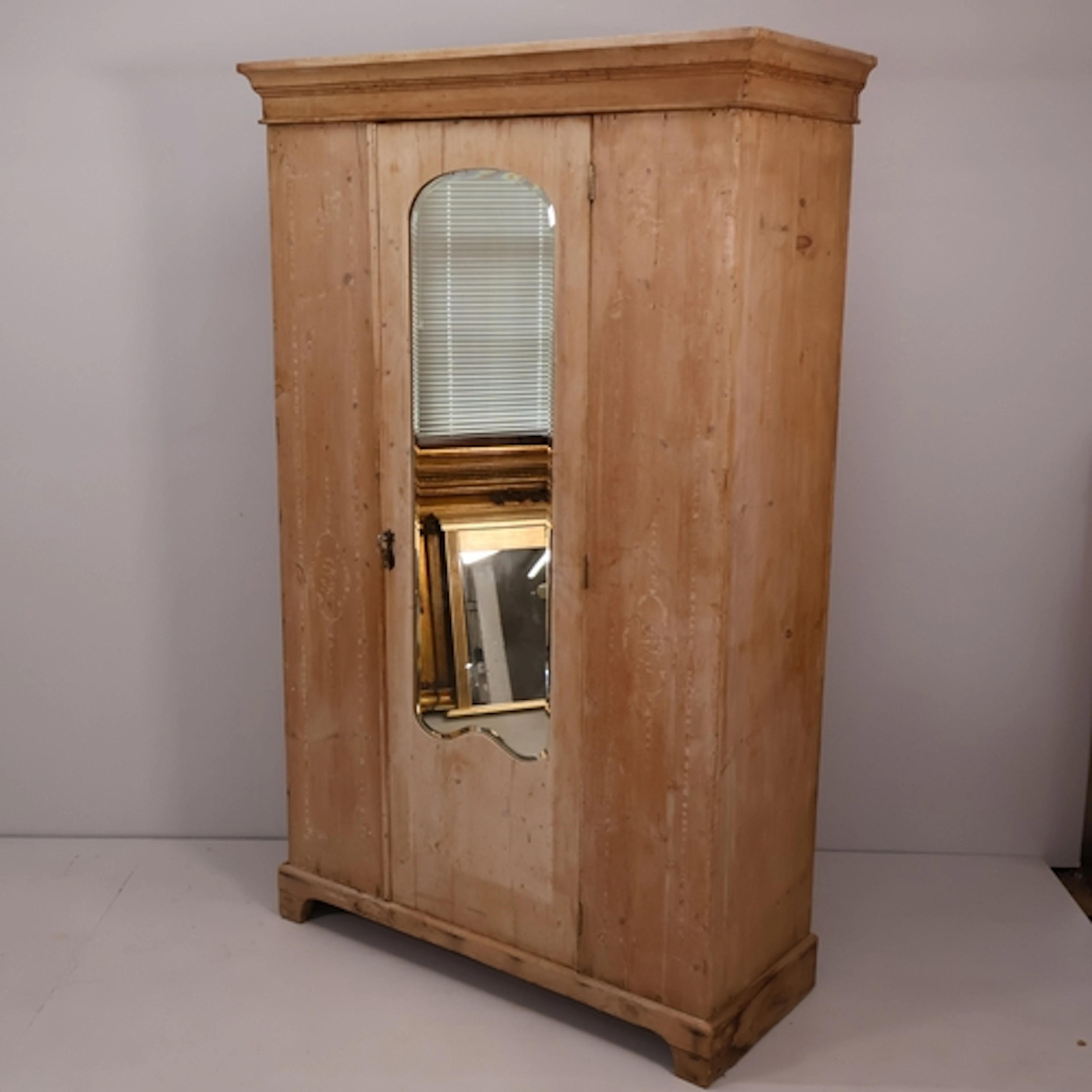 An antique pine wardrobe, with single mirrored door, rail an...