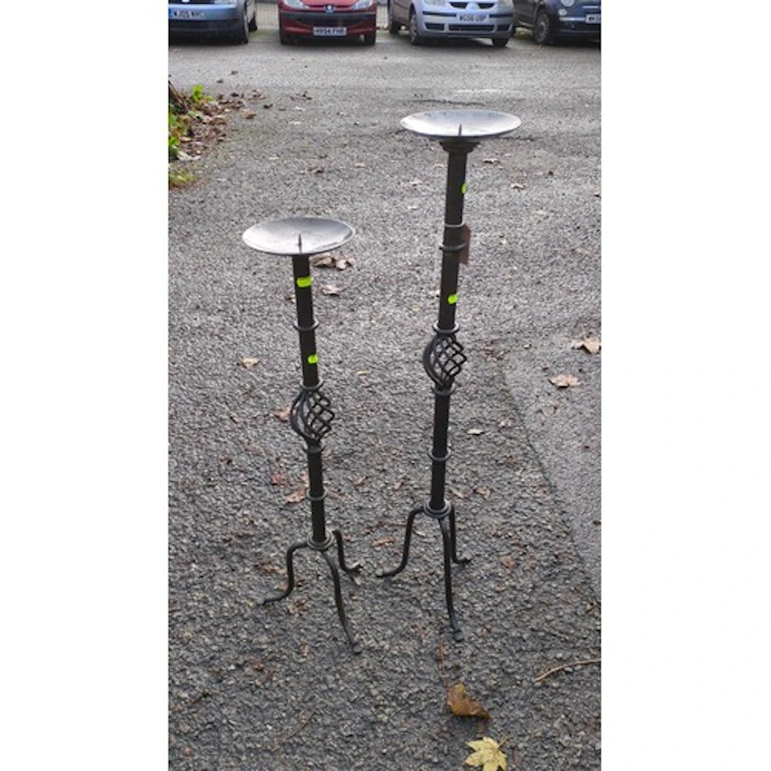 A pair of wrought-iron floor candlesticks of differing heigh...