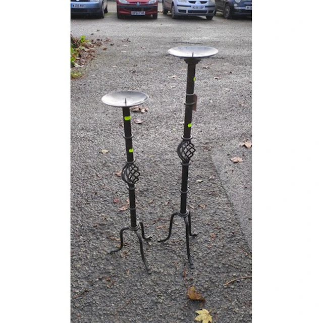 A pair of wrought-iron floor candlesticks of differing heigh...
