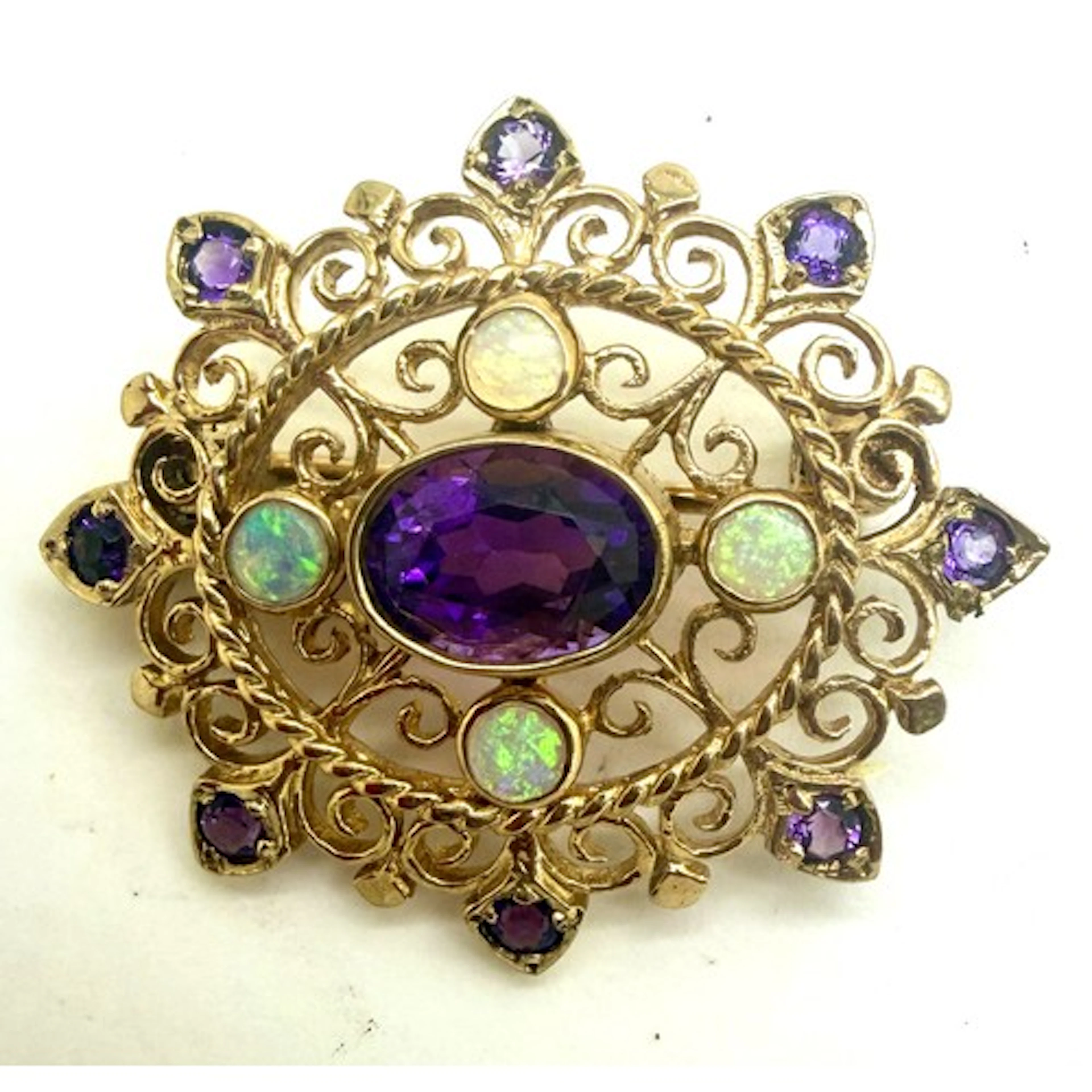 A 9 carat gold brooch/pendant set with amethyst and opals. 3...