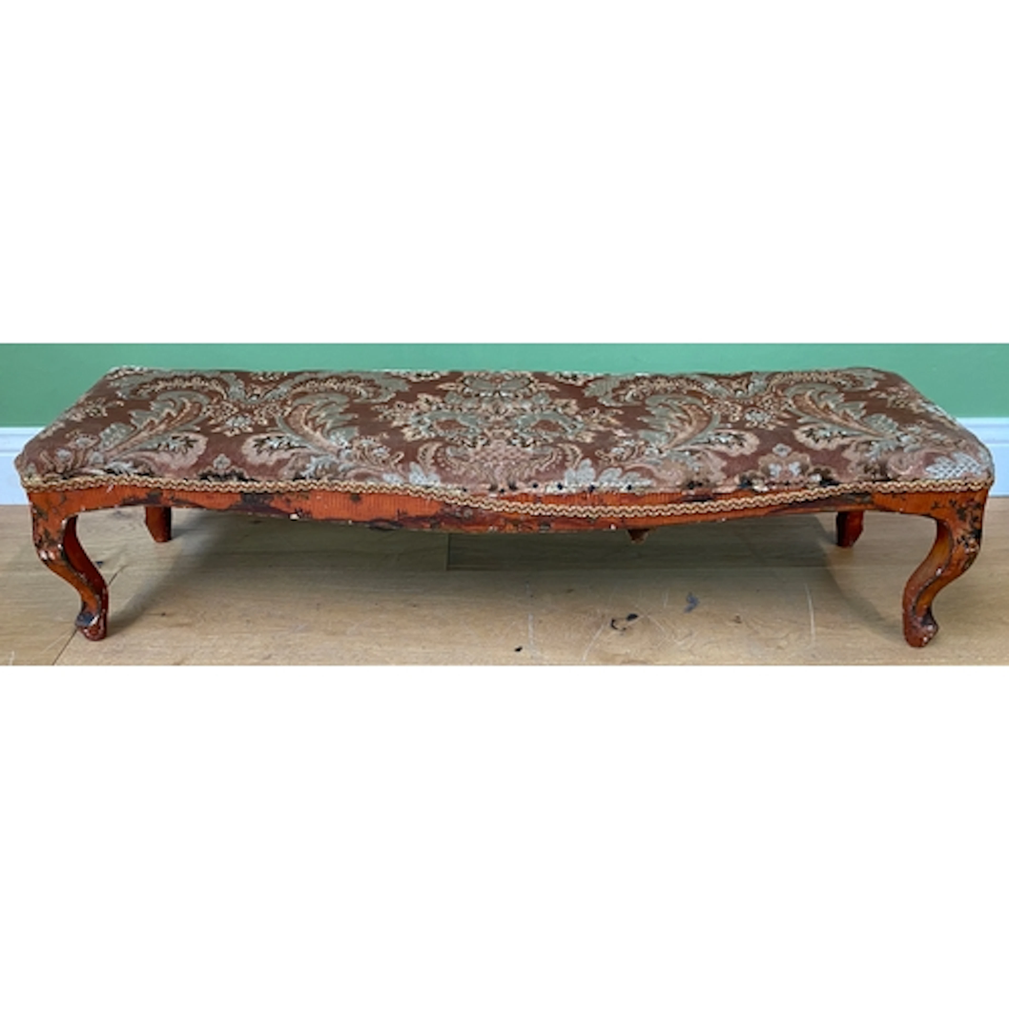A 19th century red Japanned long footstool, the stuff over s...