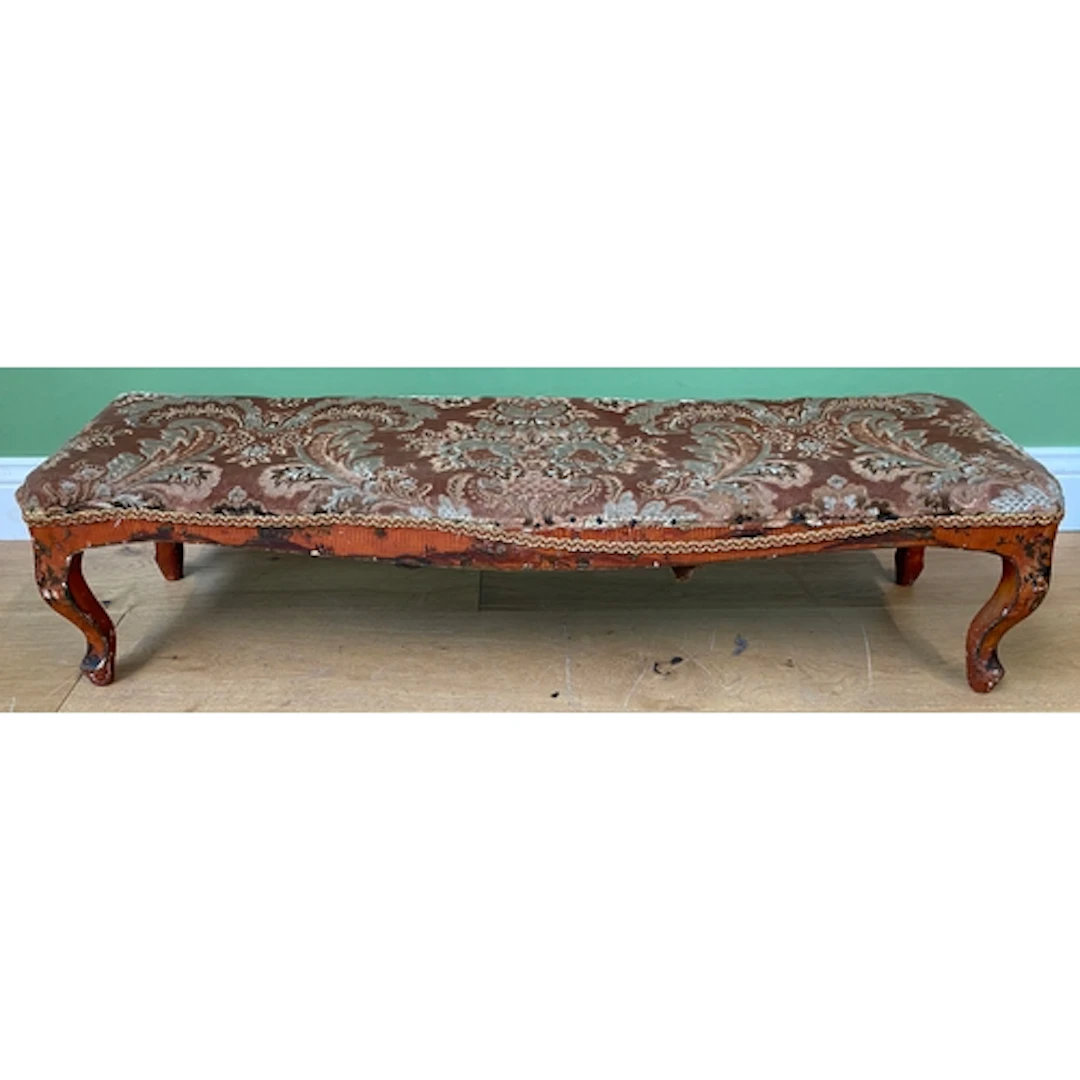 A 19th century red Japanned long footstool, the stuff over s...
