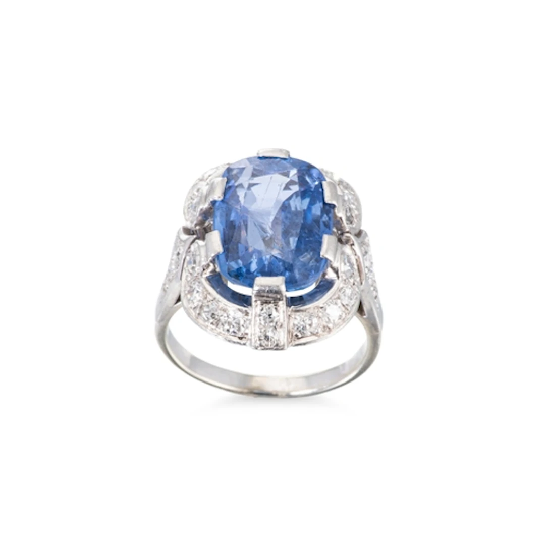 A SAPPHIRE AND DIAMOND CLUSTER RING, the cushion cut sapphir...